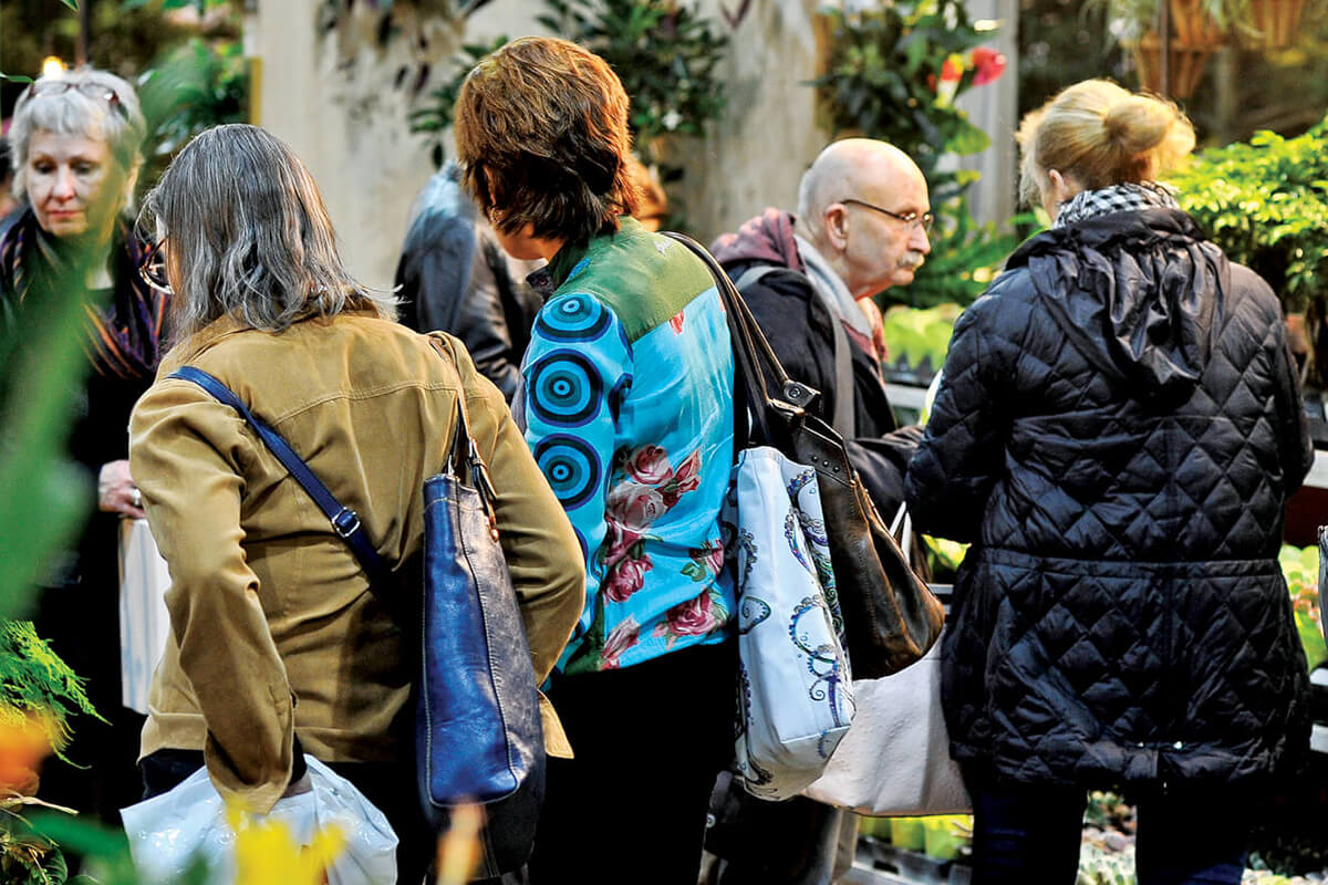 people shopping for plants at an indoor marketplace