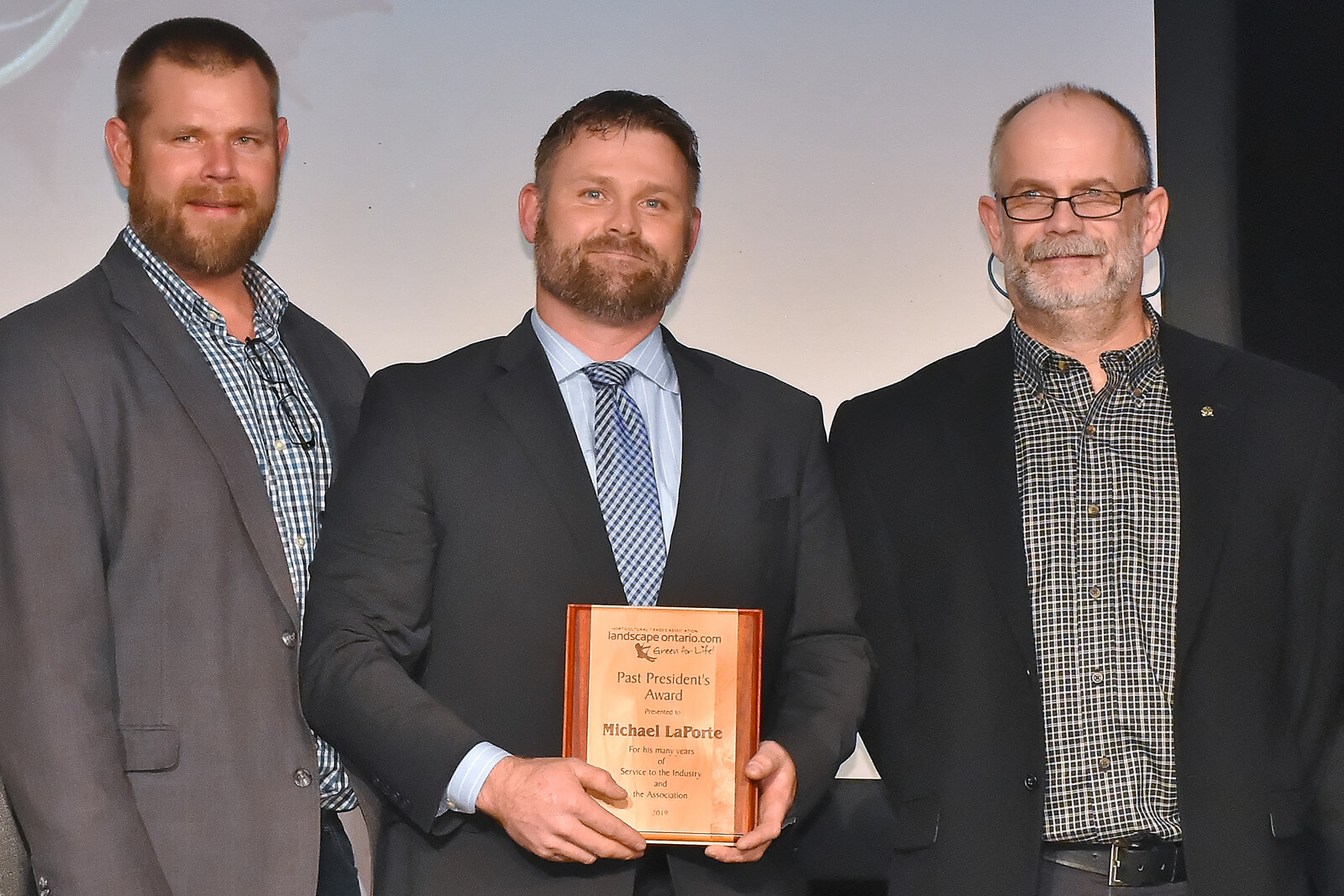Michael LaPorte (centre), accepts the 2019 Past President's Award.