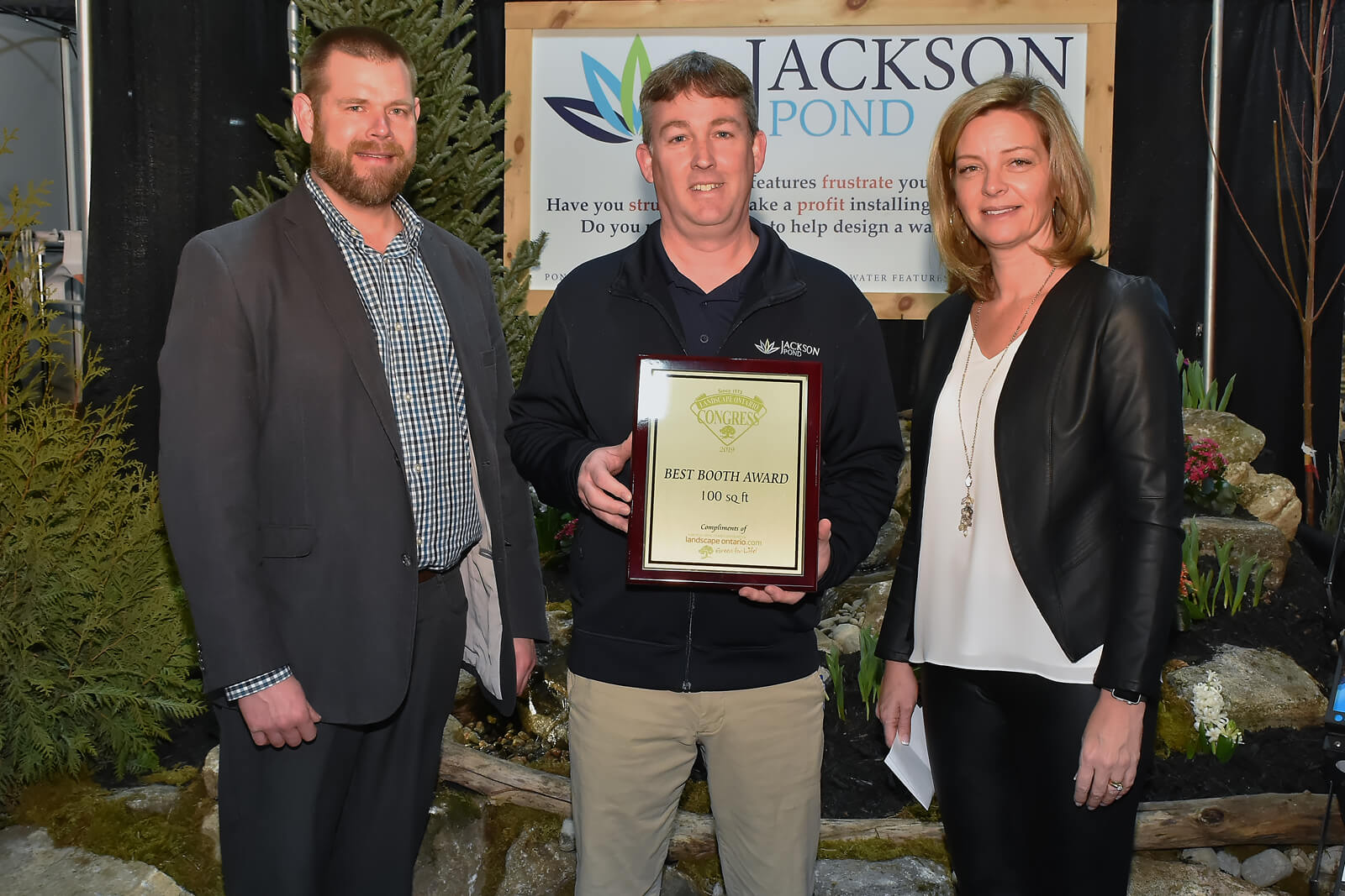 booth winner holding plaque