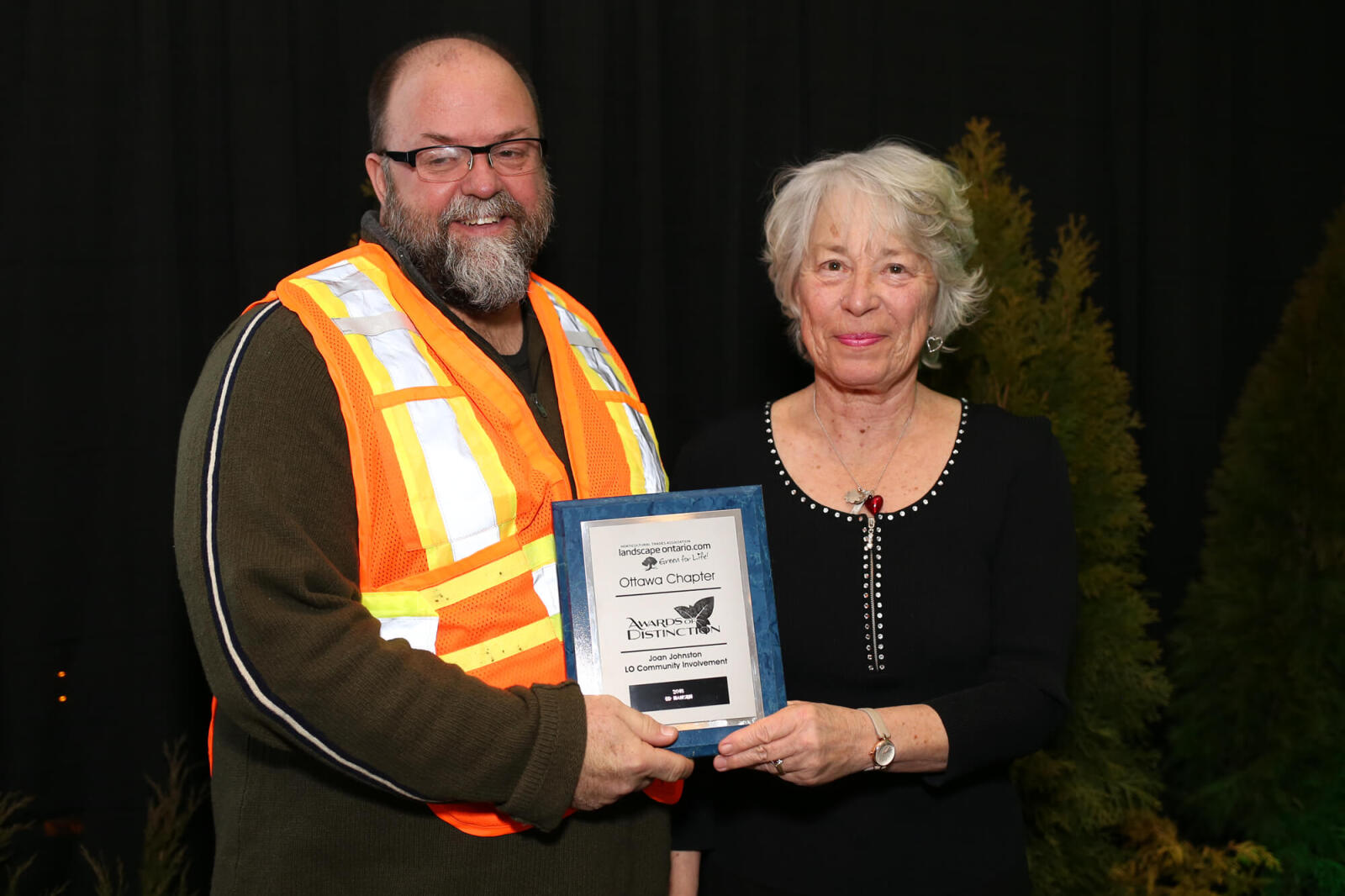 man accepting an award from a woman