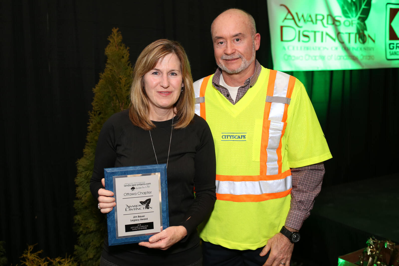 woman holding a plaque beside a man