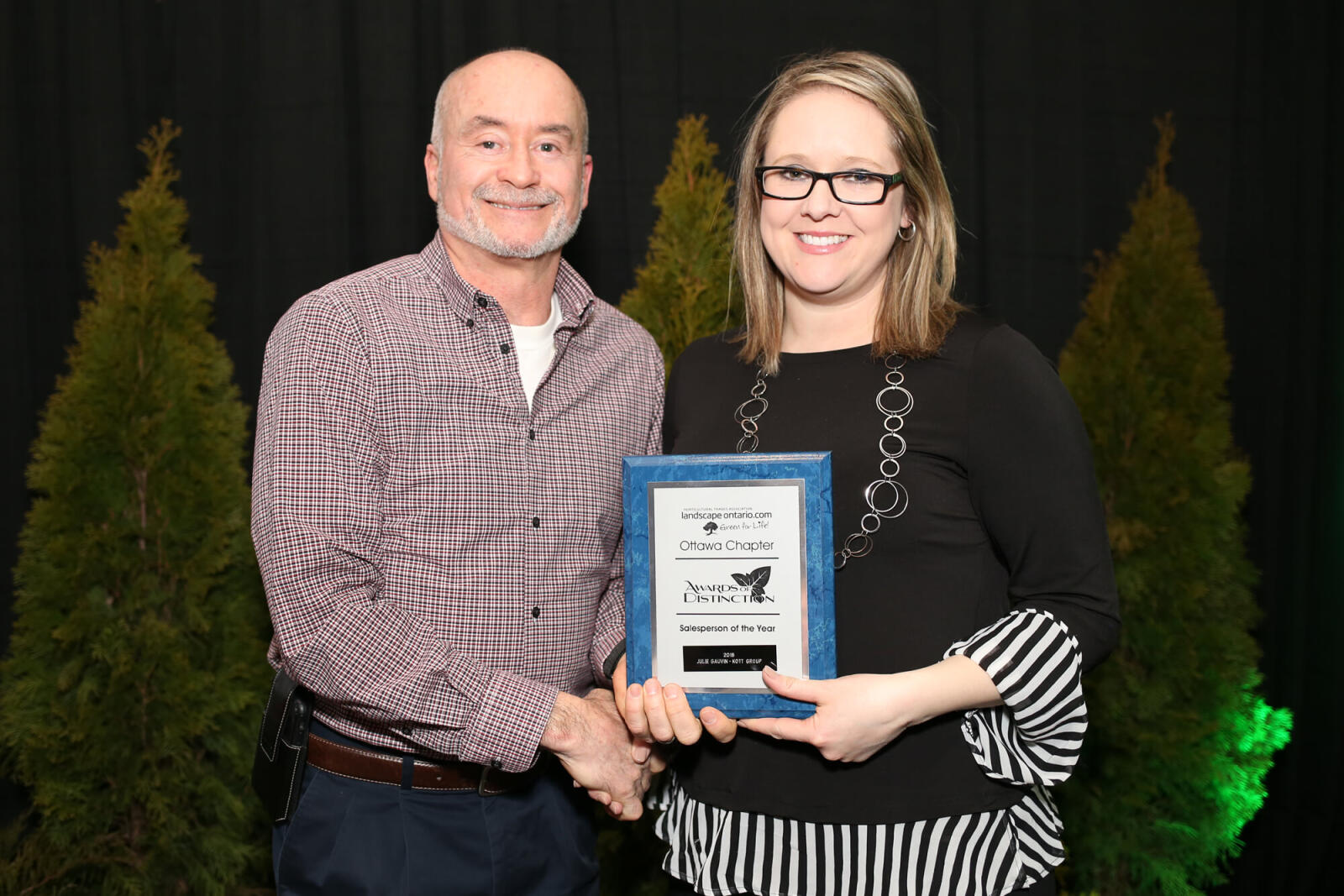 man and woman holding an award plaque