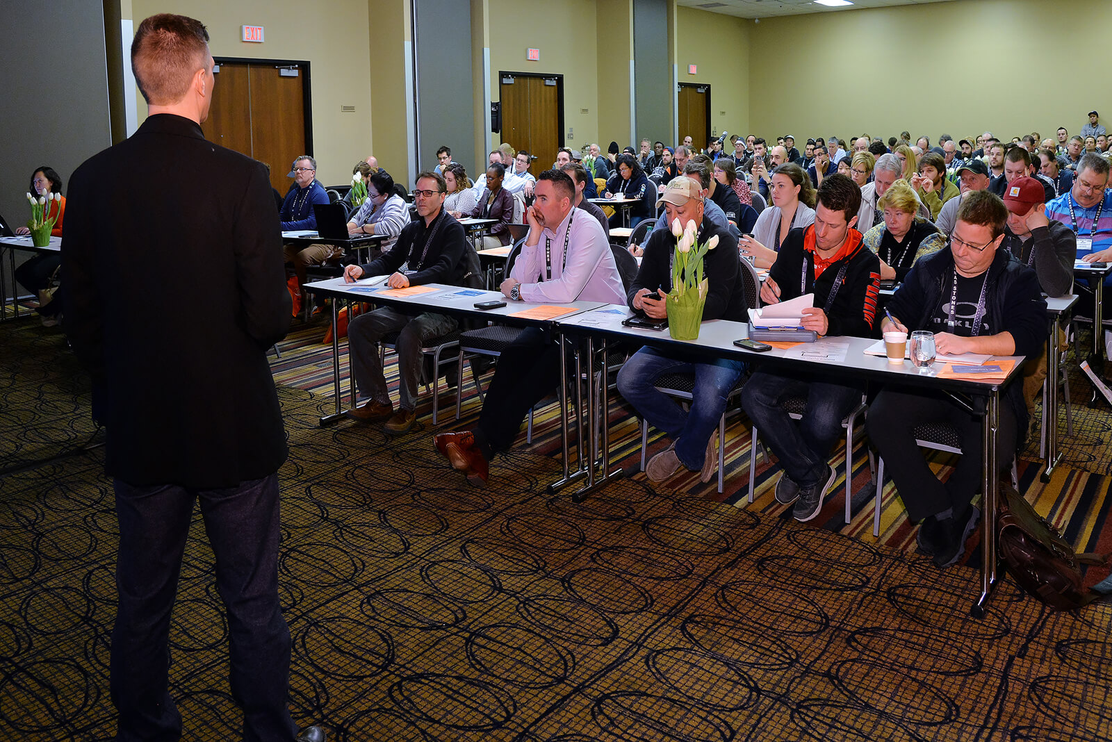 person leading a conference session in a full room