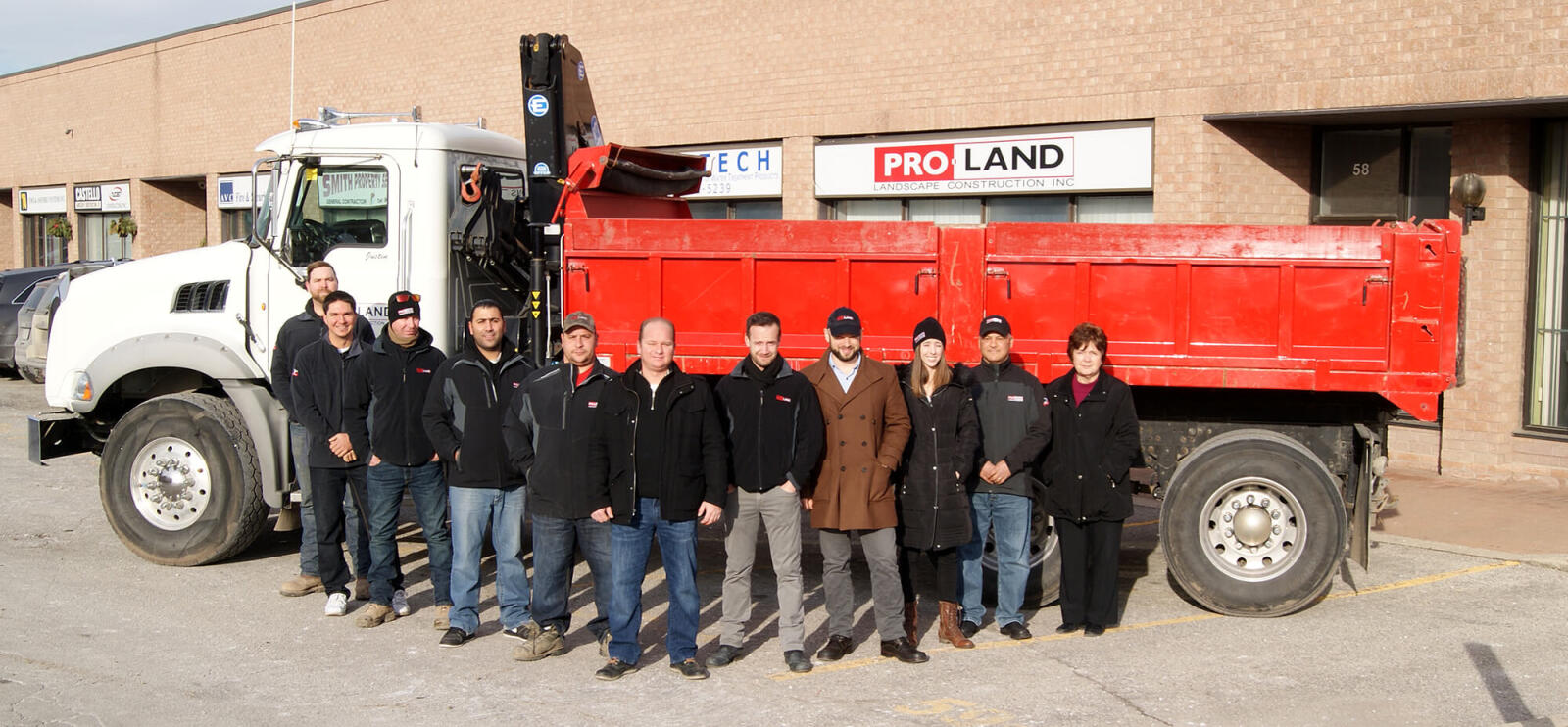 group of workers gathered in front of a large truck at place of business