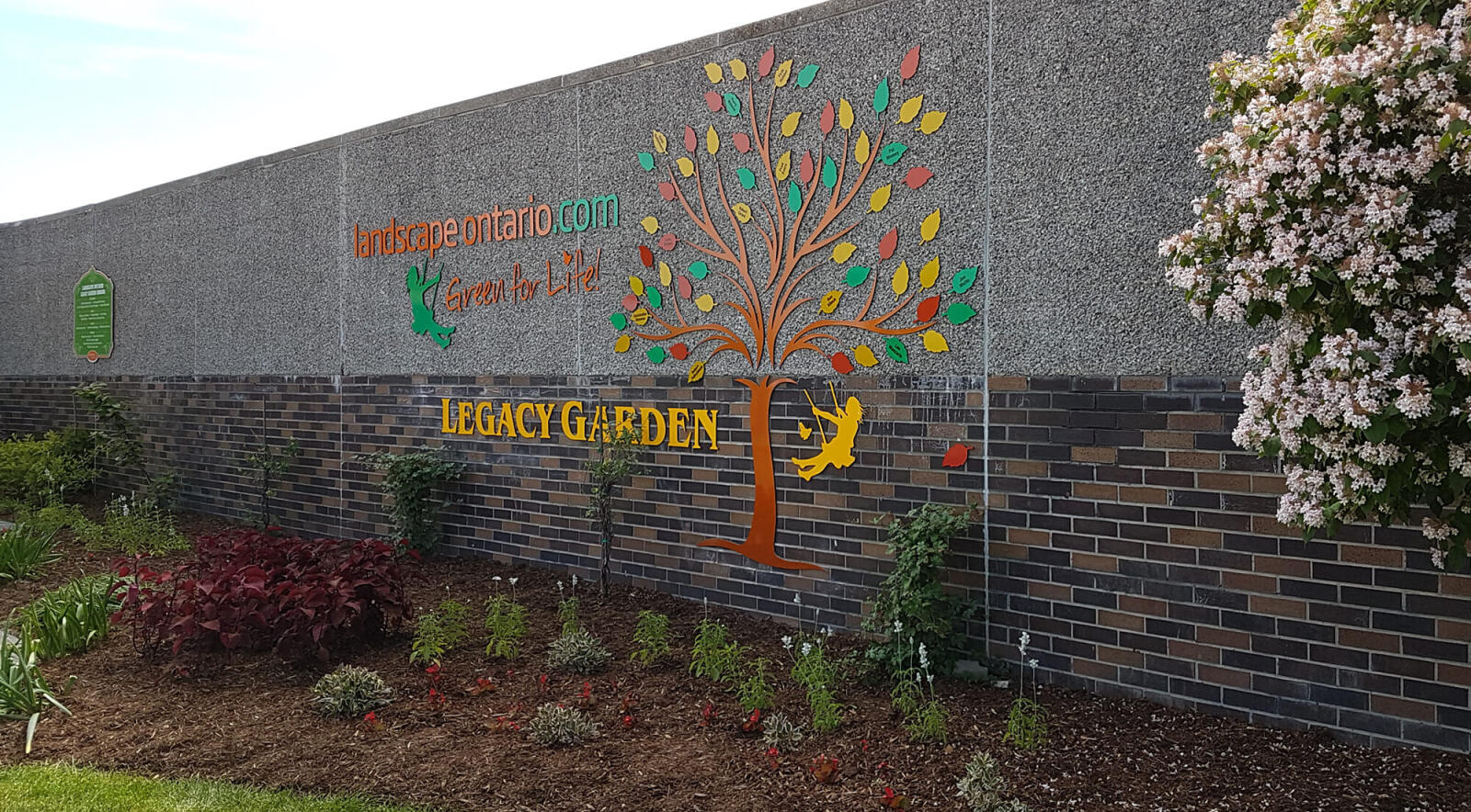 logo on a wall in a garden