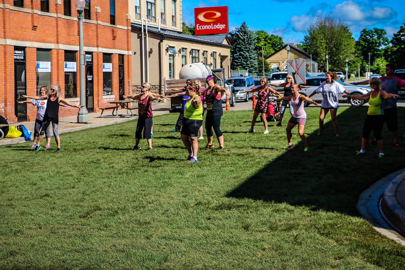 people exercising on a downtown street covered in grass