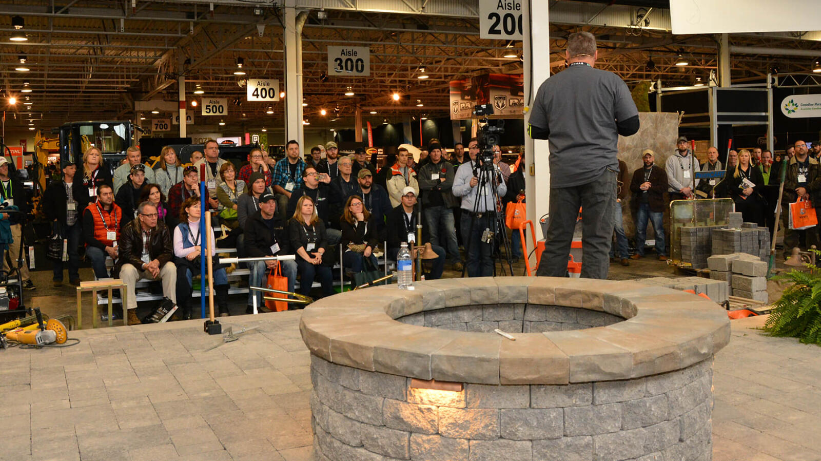 presenter talking to crowd at a trade show demo area