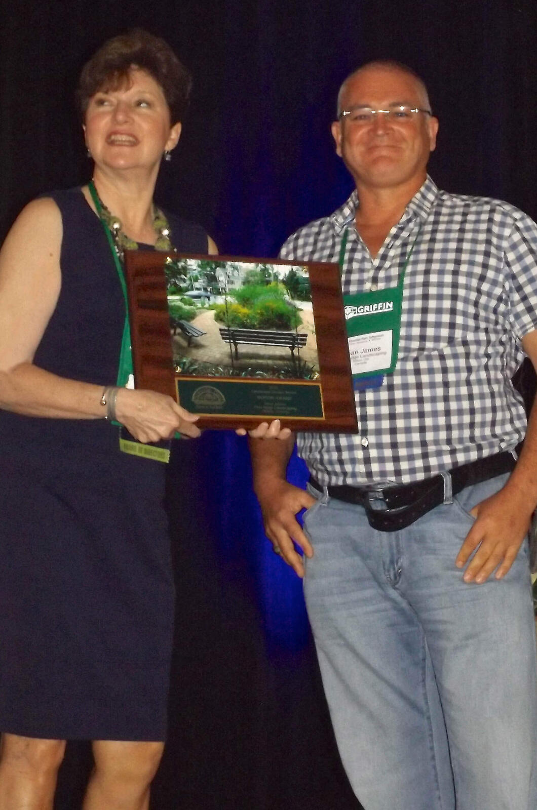 woman presenting an award to a man on stage