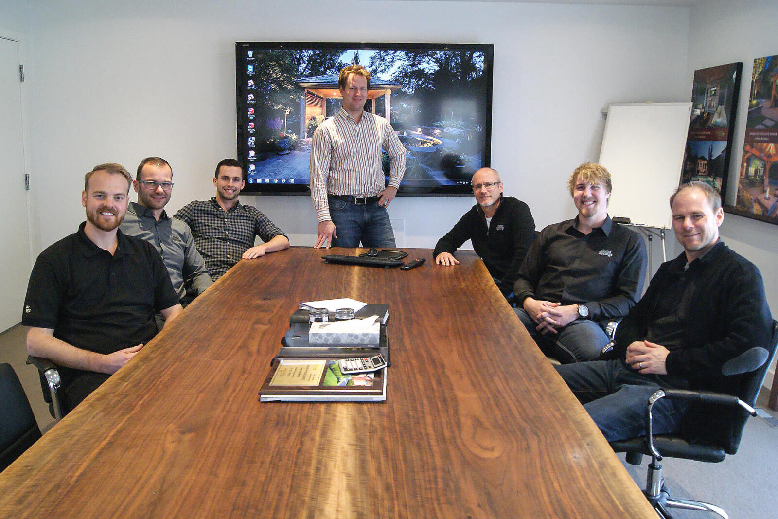 large table with people seated around it and one man standing at the end