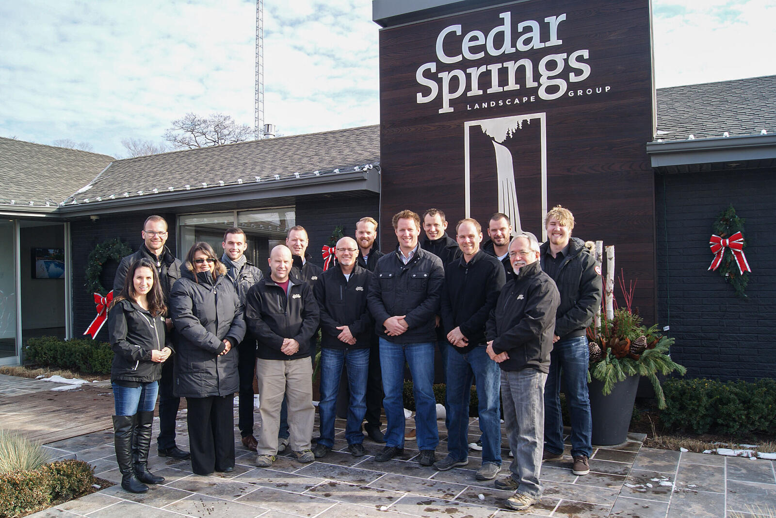 large group of people standing outside their pace of business in winter.
