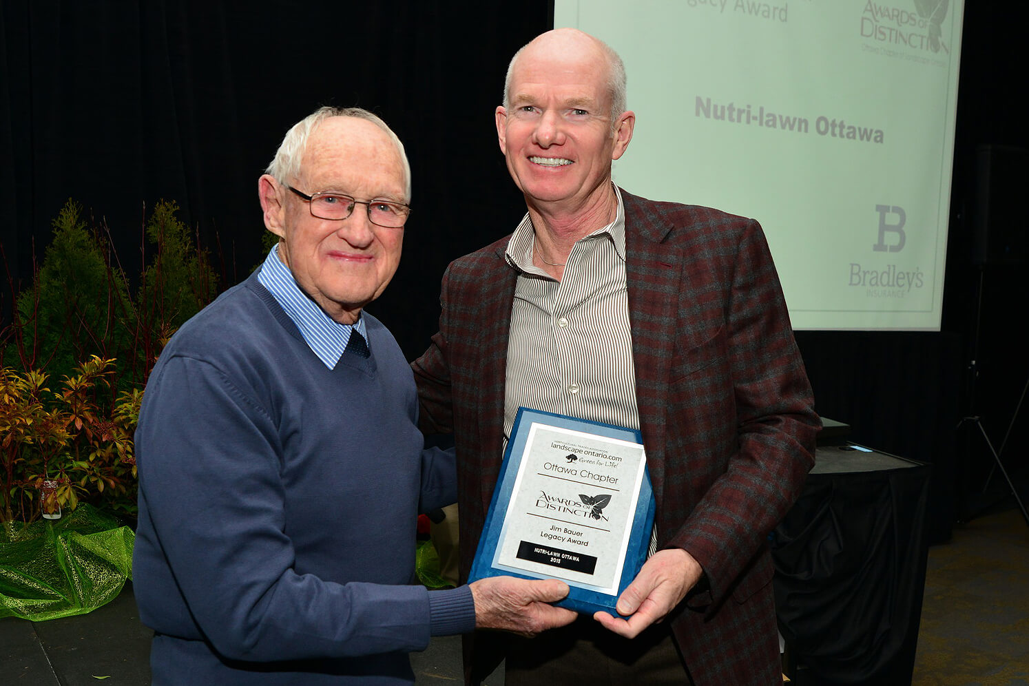 man presenting and award to another man