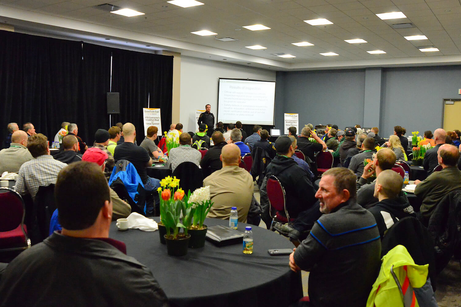 large room full of people watching a presentation
