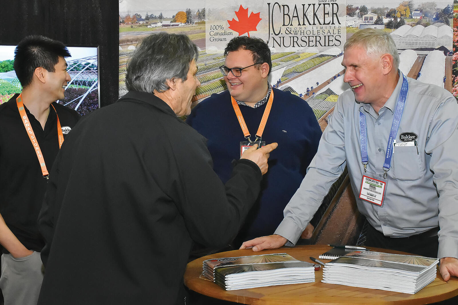 three happy men doing business at a trade show