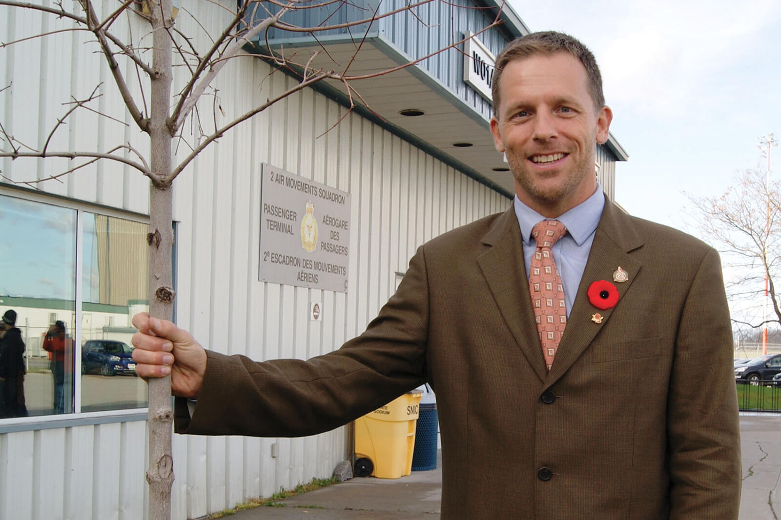 scott bryk standing next to the newly-planted tree