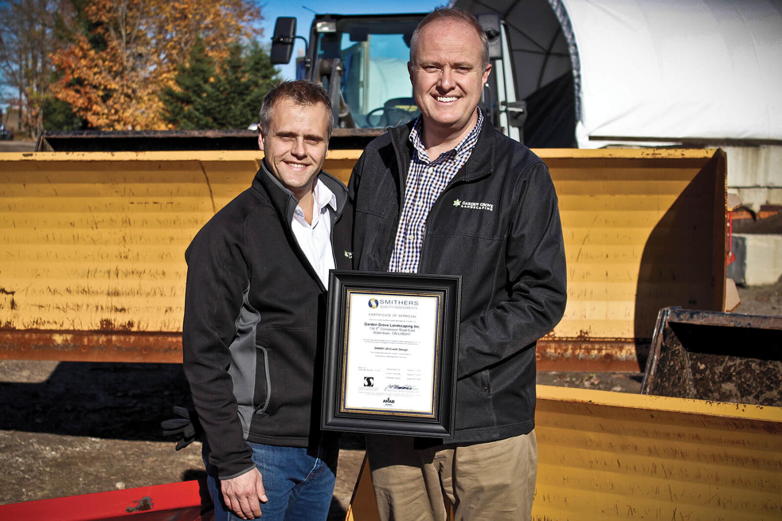 paul and david holding an award outside