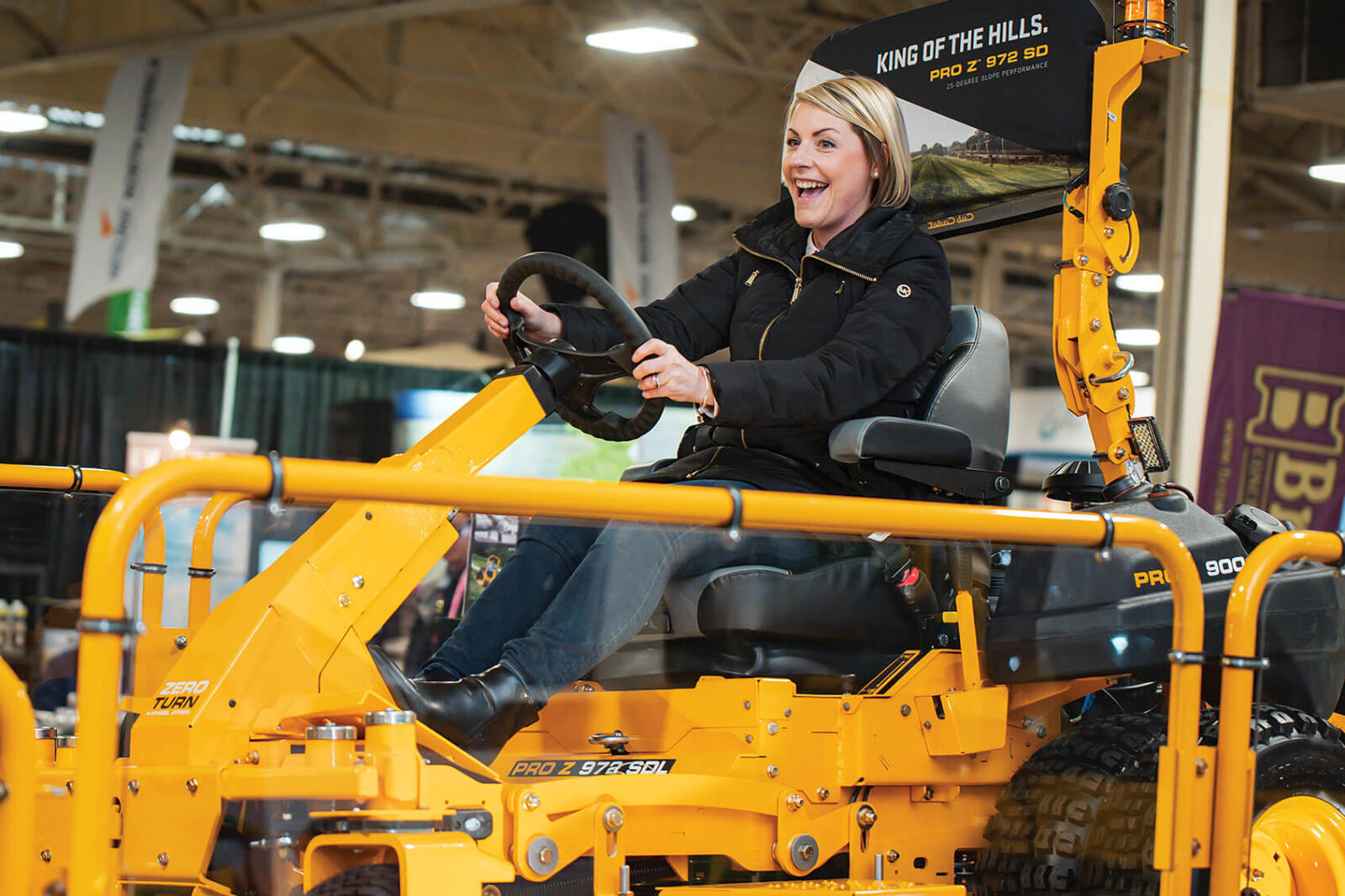 woman sitting on a commerical lawn mower