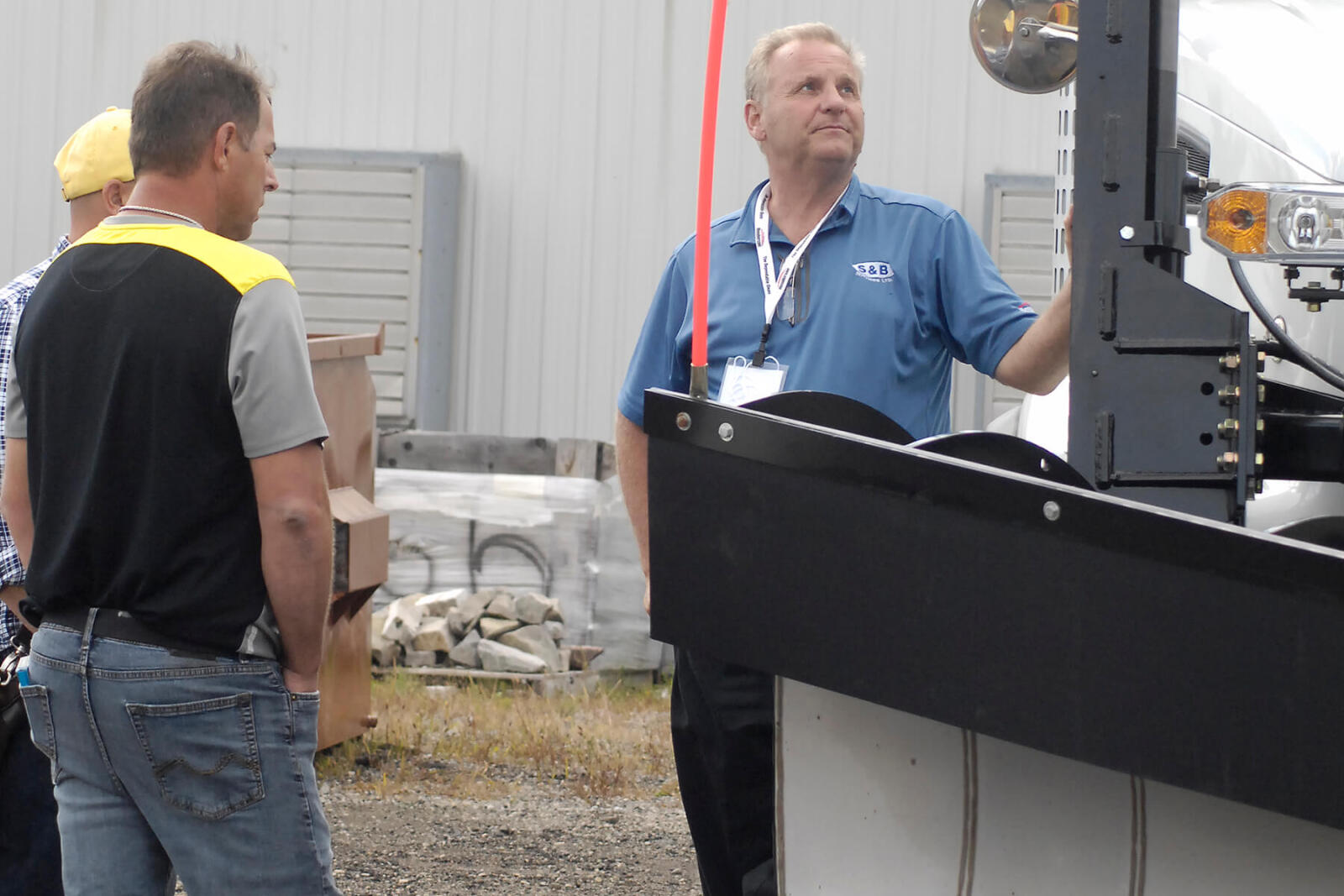 men lookin at a large snow plow