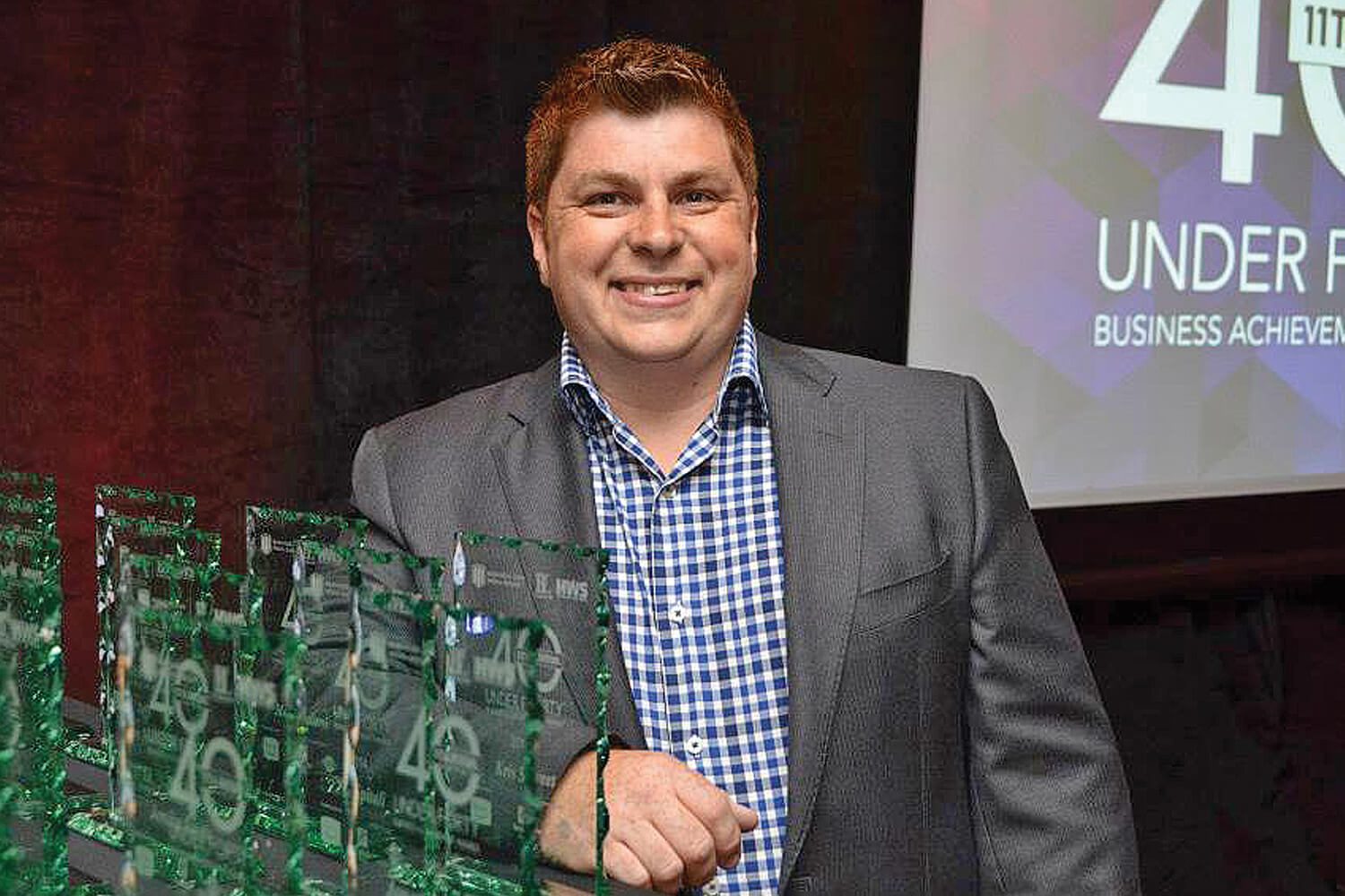 man posing in front of an award