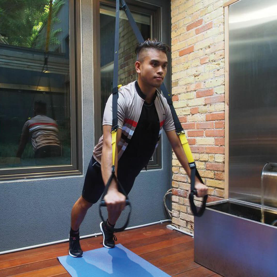 man doing push ups with a harness