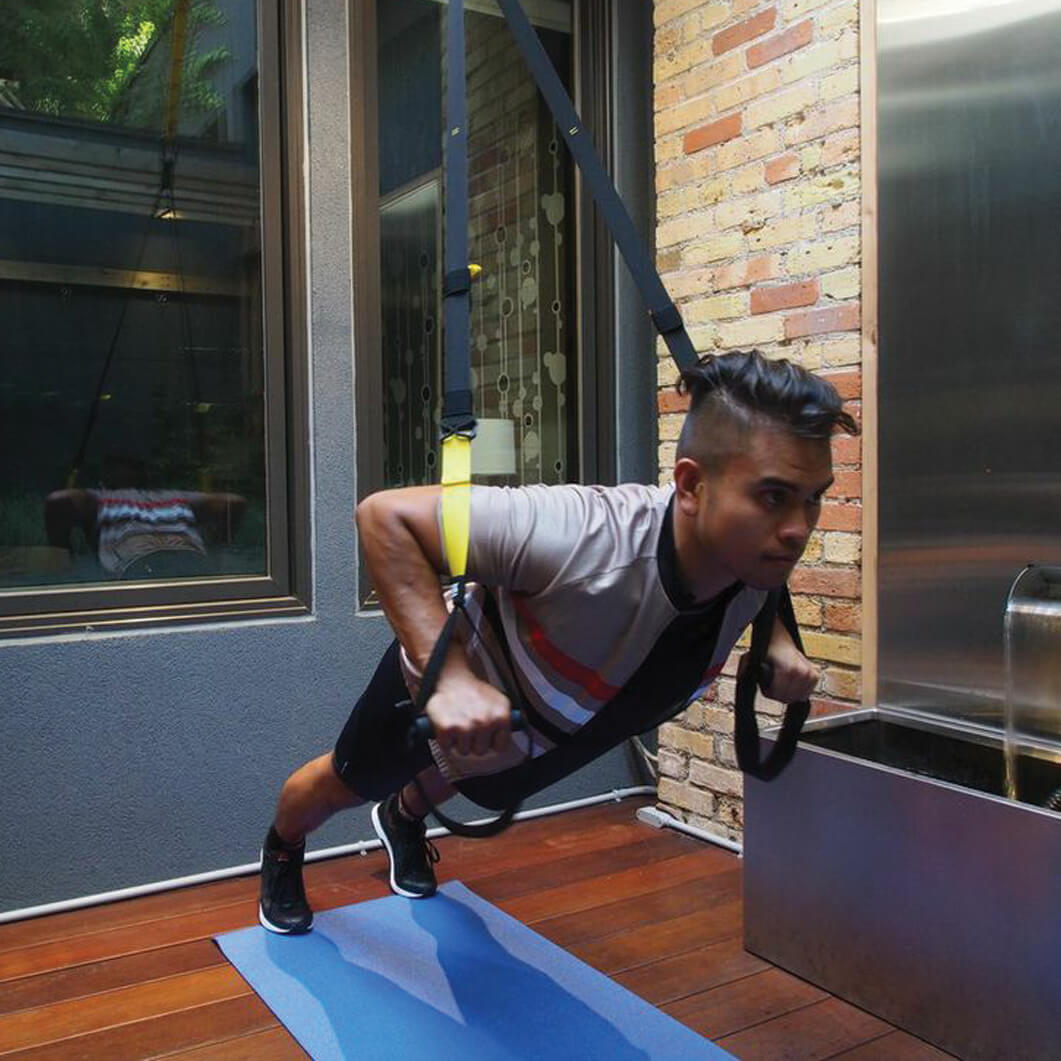 man doing push ups with a harness