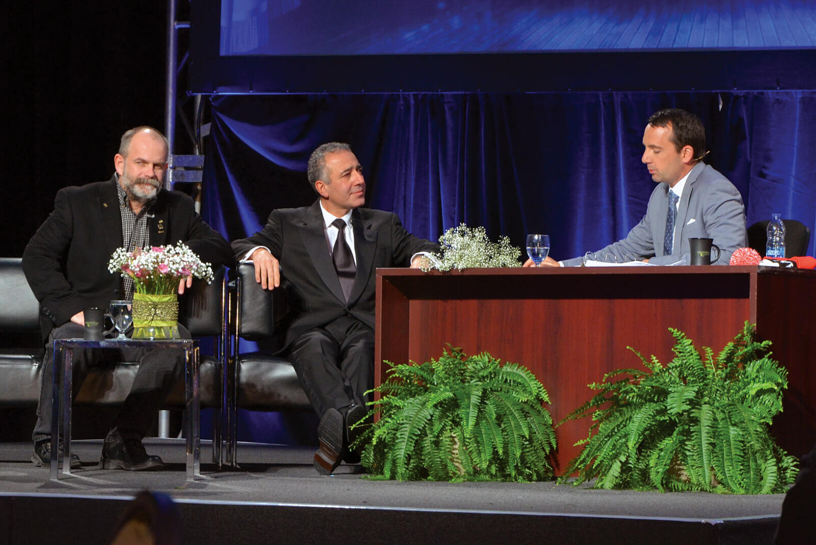 three men in a talk show style setting