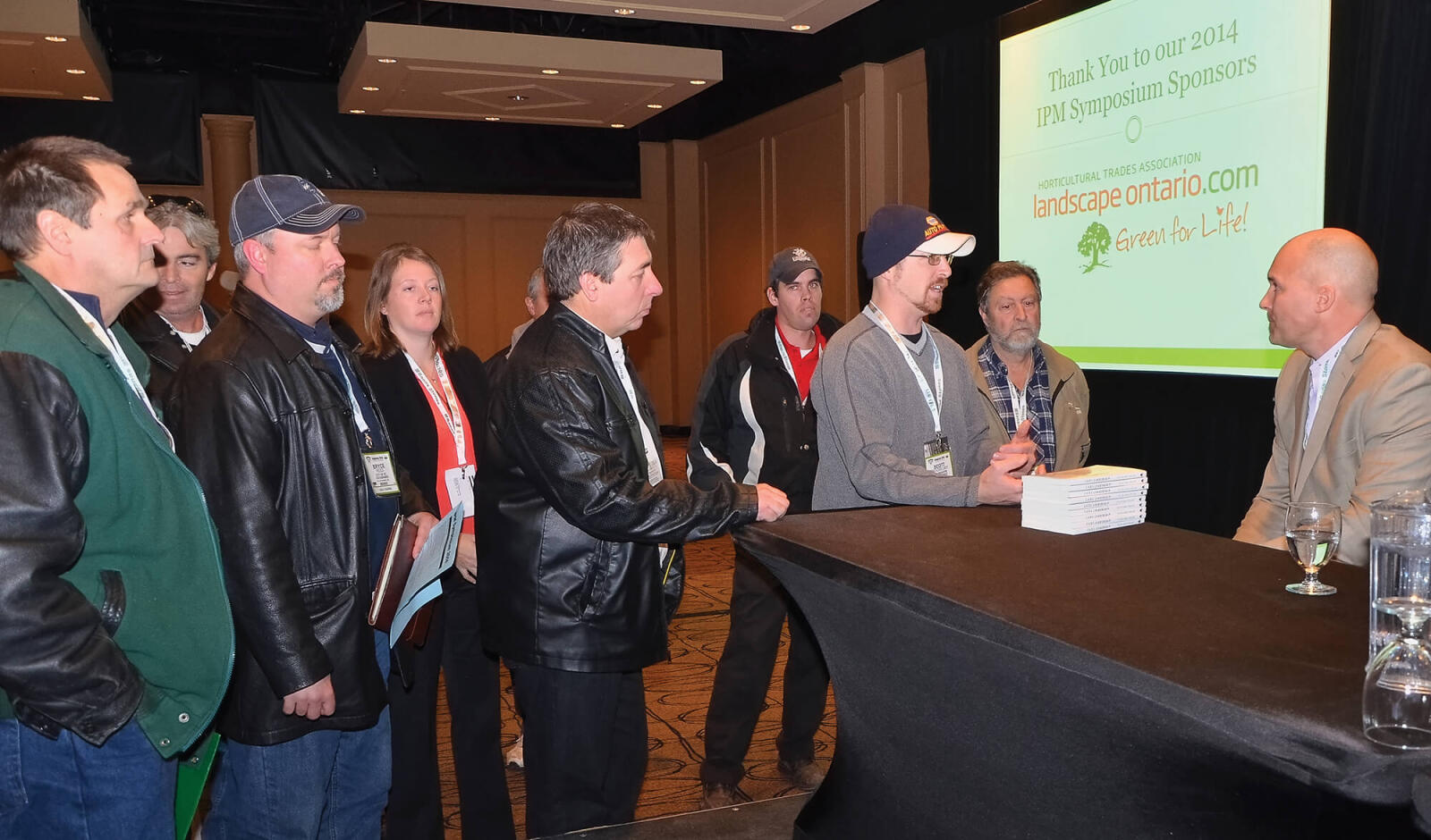 line of men waiting to speak with a man seated behind a table