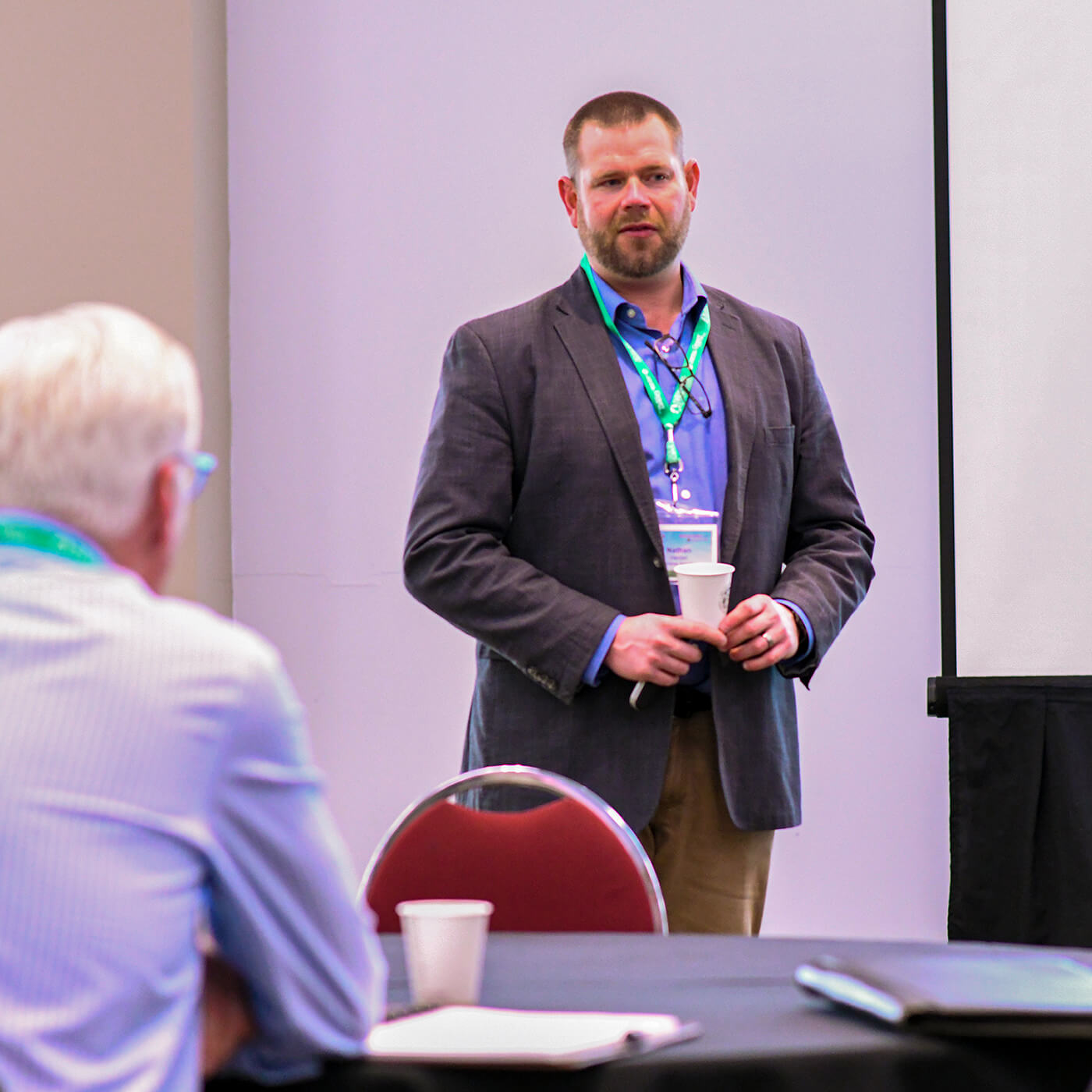 man speaking to a crowd at a seminar