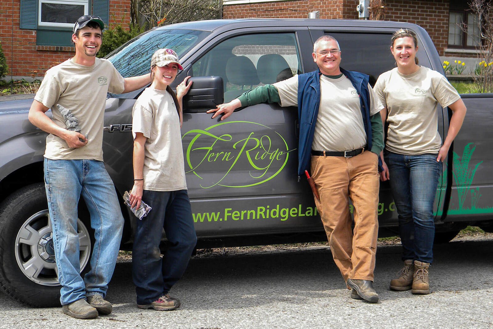 4 people standing in front of a pick up truck