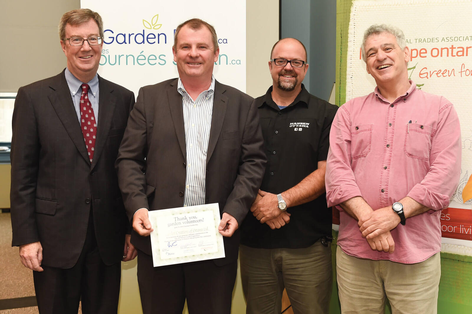 four men. one holding a certificate