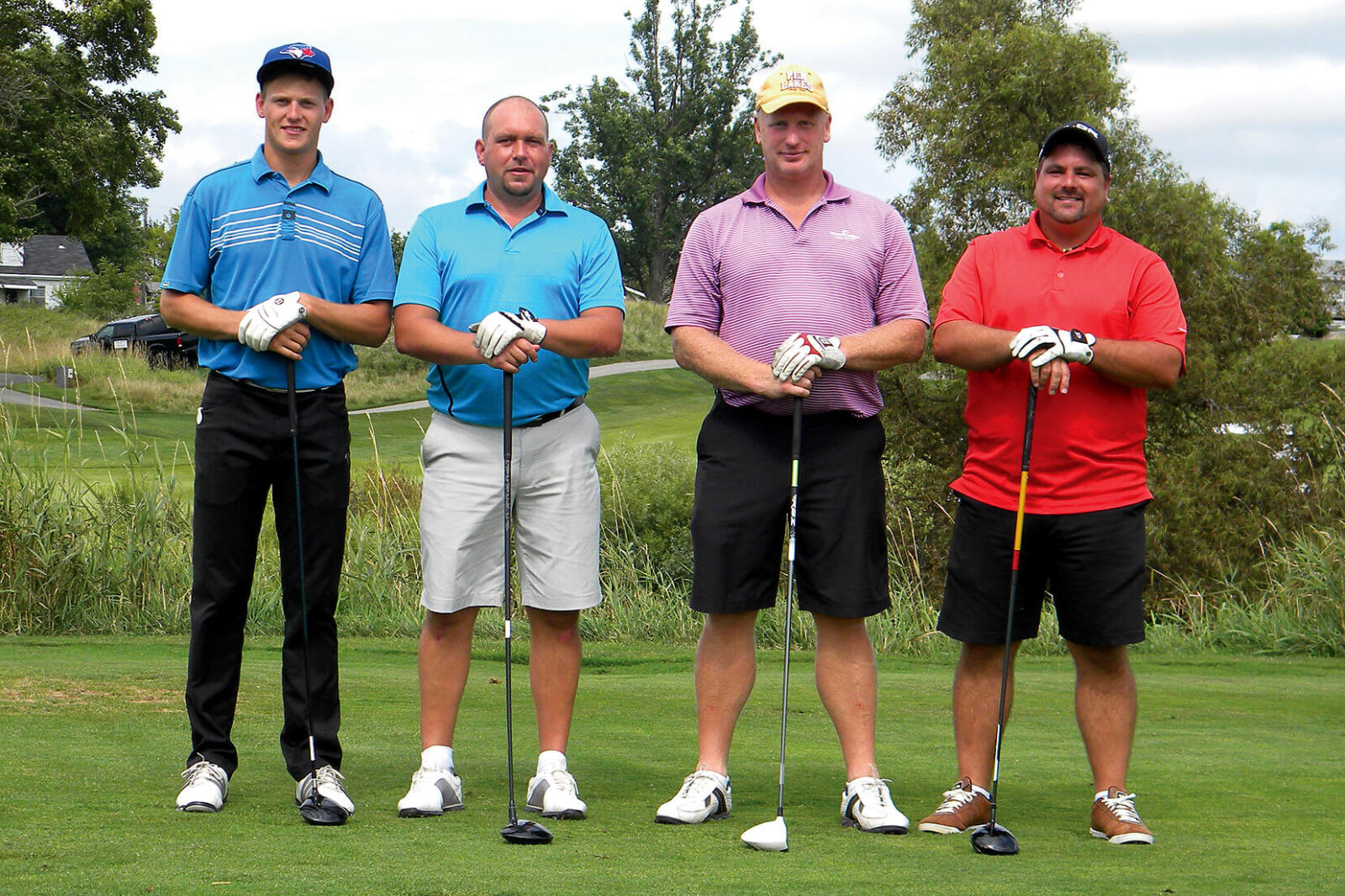 four golfers posing on the golf course