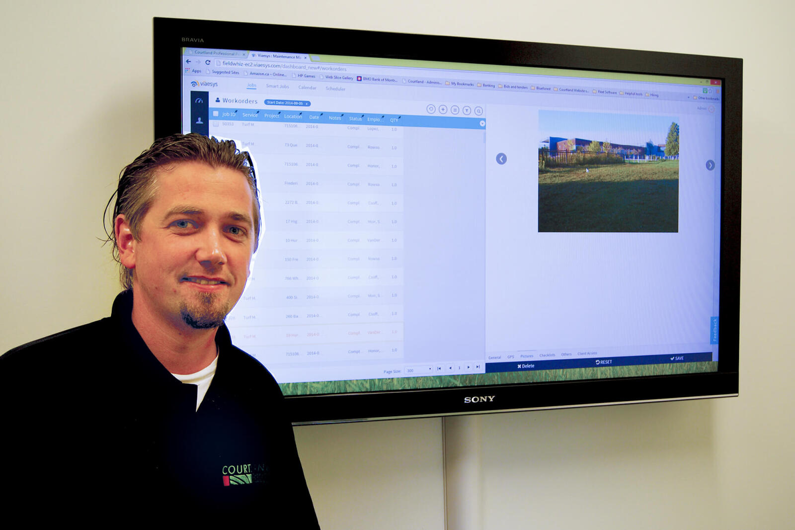 man standing in front of a flat screen tv