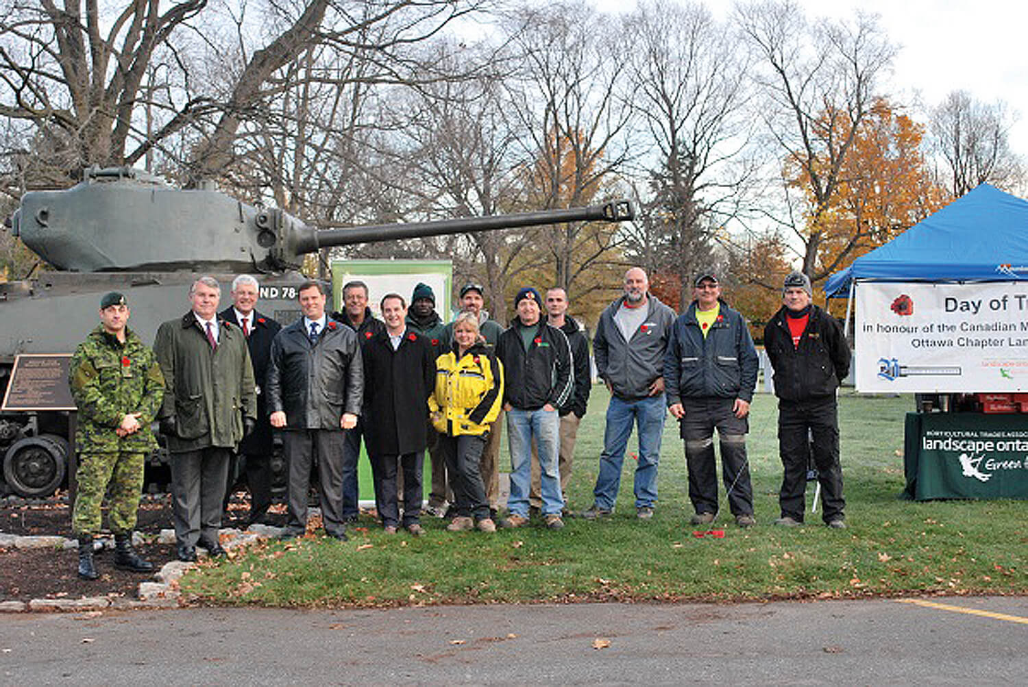 group of volunteers standing in front of a tank