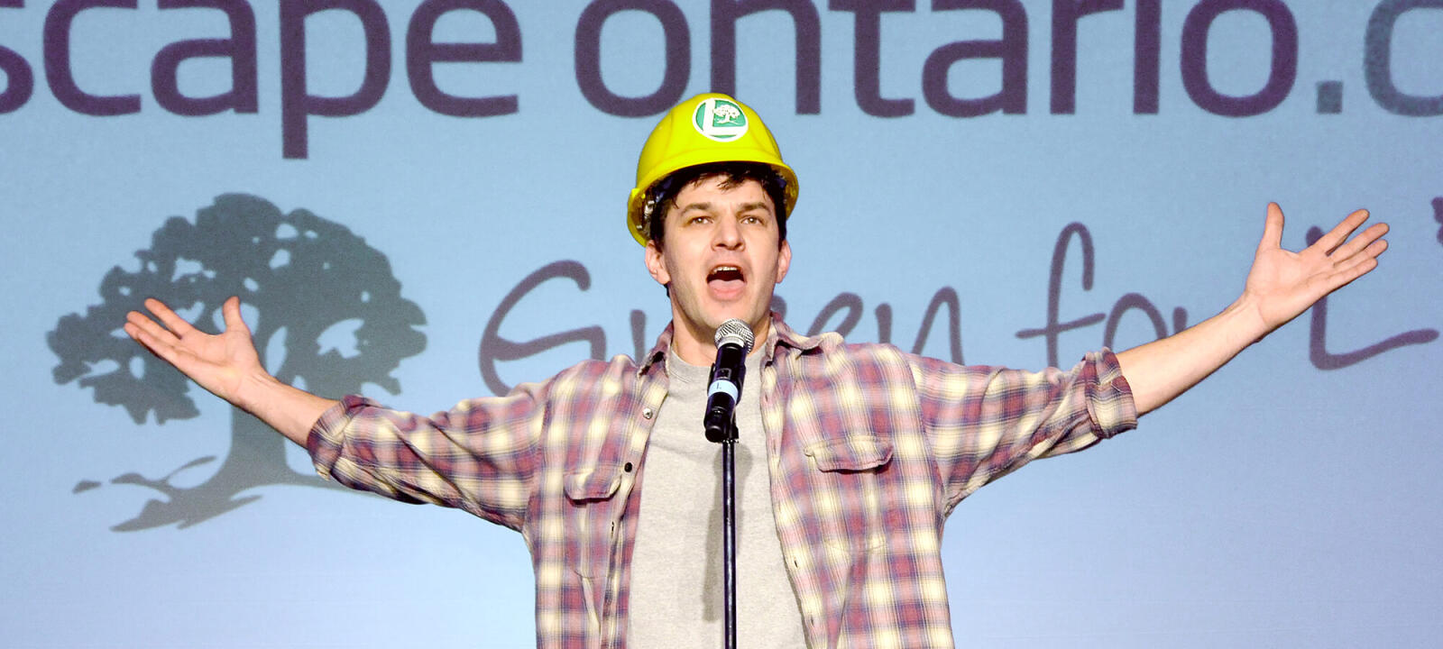 man in a construction hat on stage performing