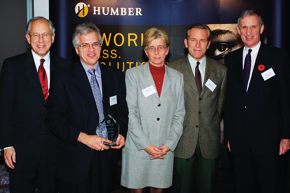 four men and a woman posing with an award