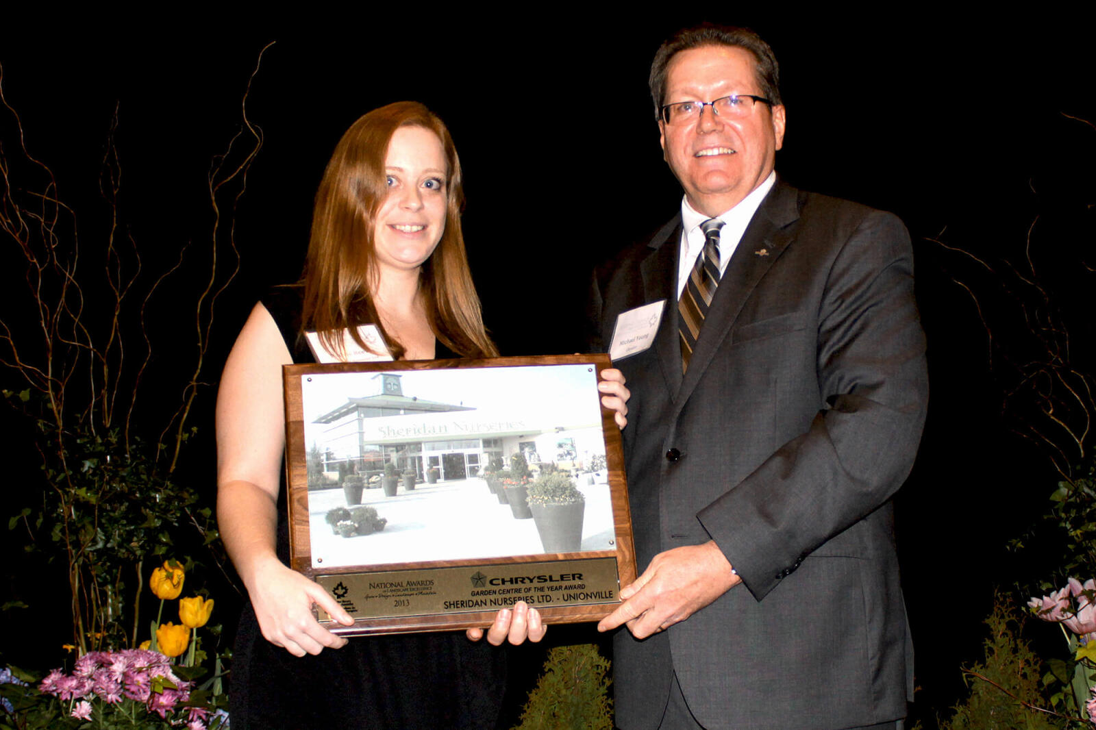 man presenting an award to a woman