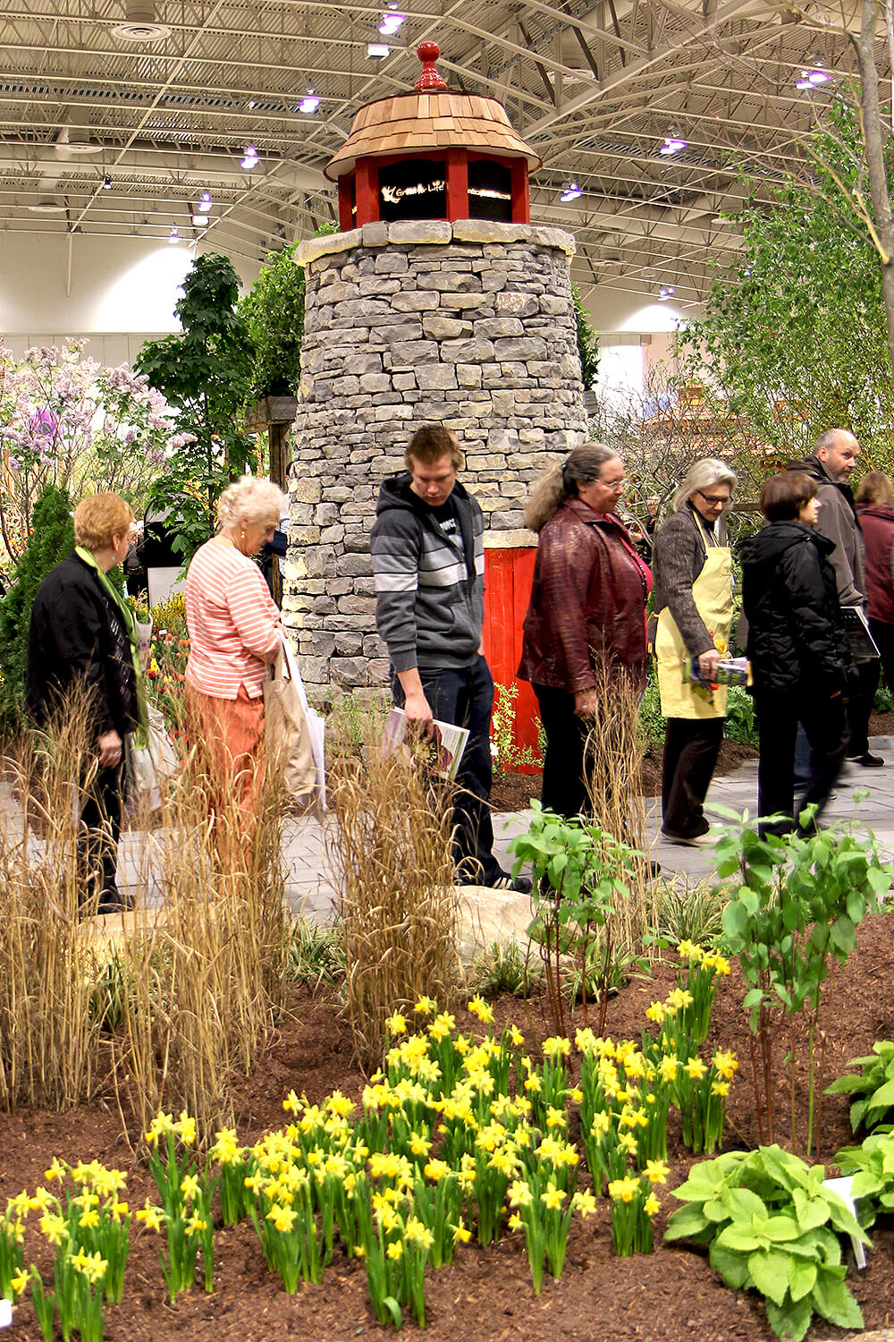 large drystone lighthouse and people looking at flowers