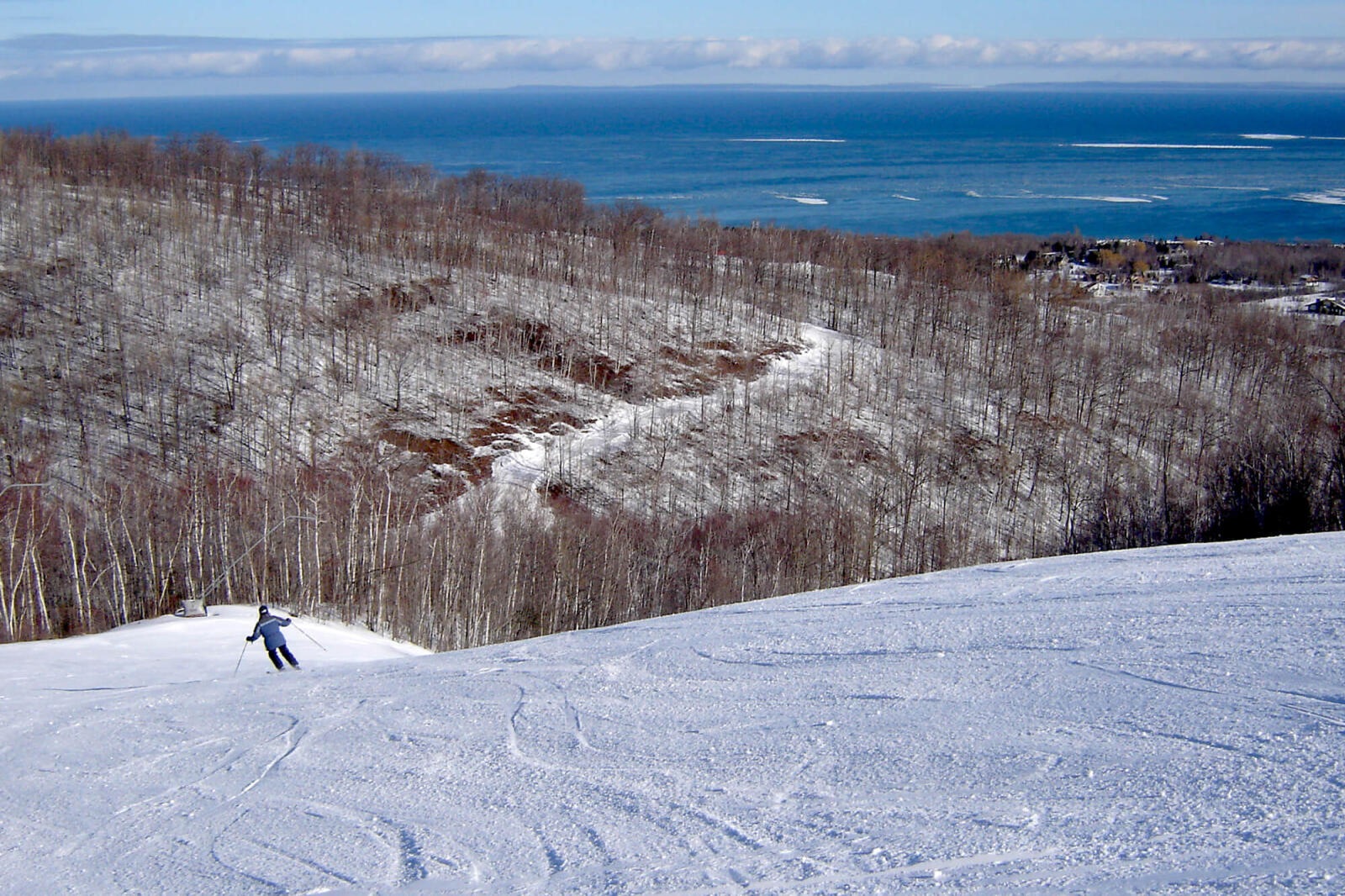 skier on a mountain overlooking a lake