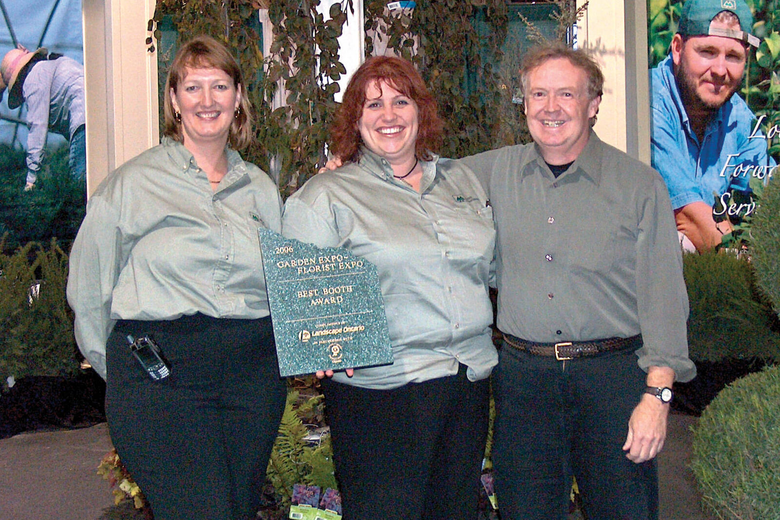 two women and a man holding an award