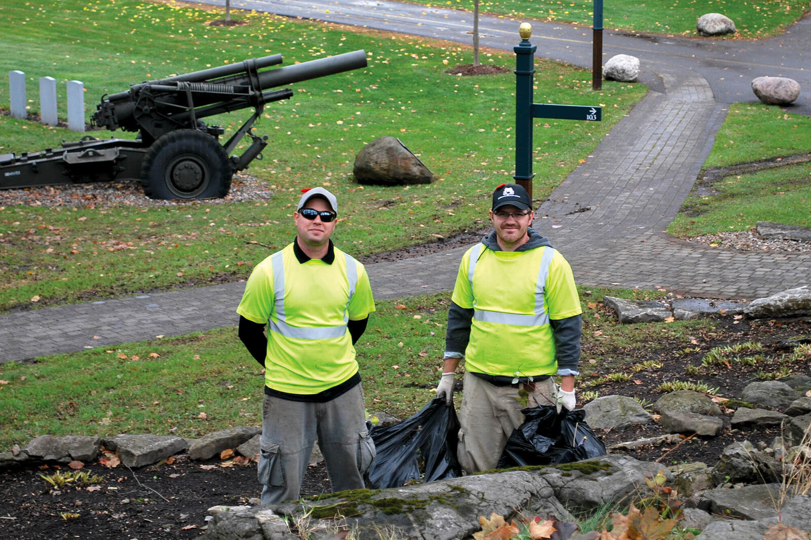 two men cleaning up a garden bed
