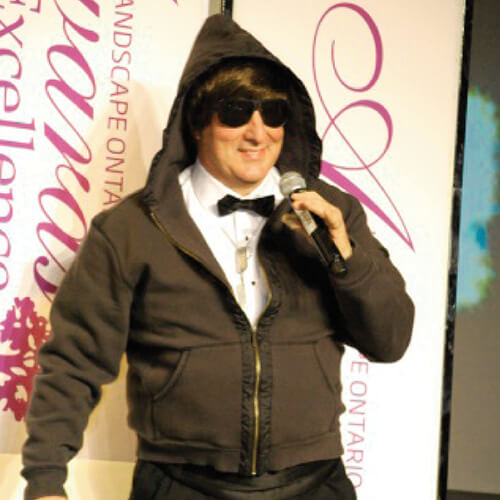 man in a hoodie and sunglasses holding a microphone