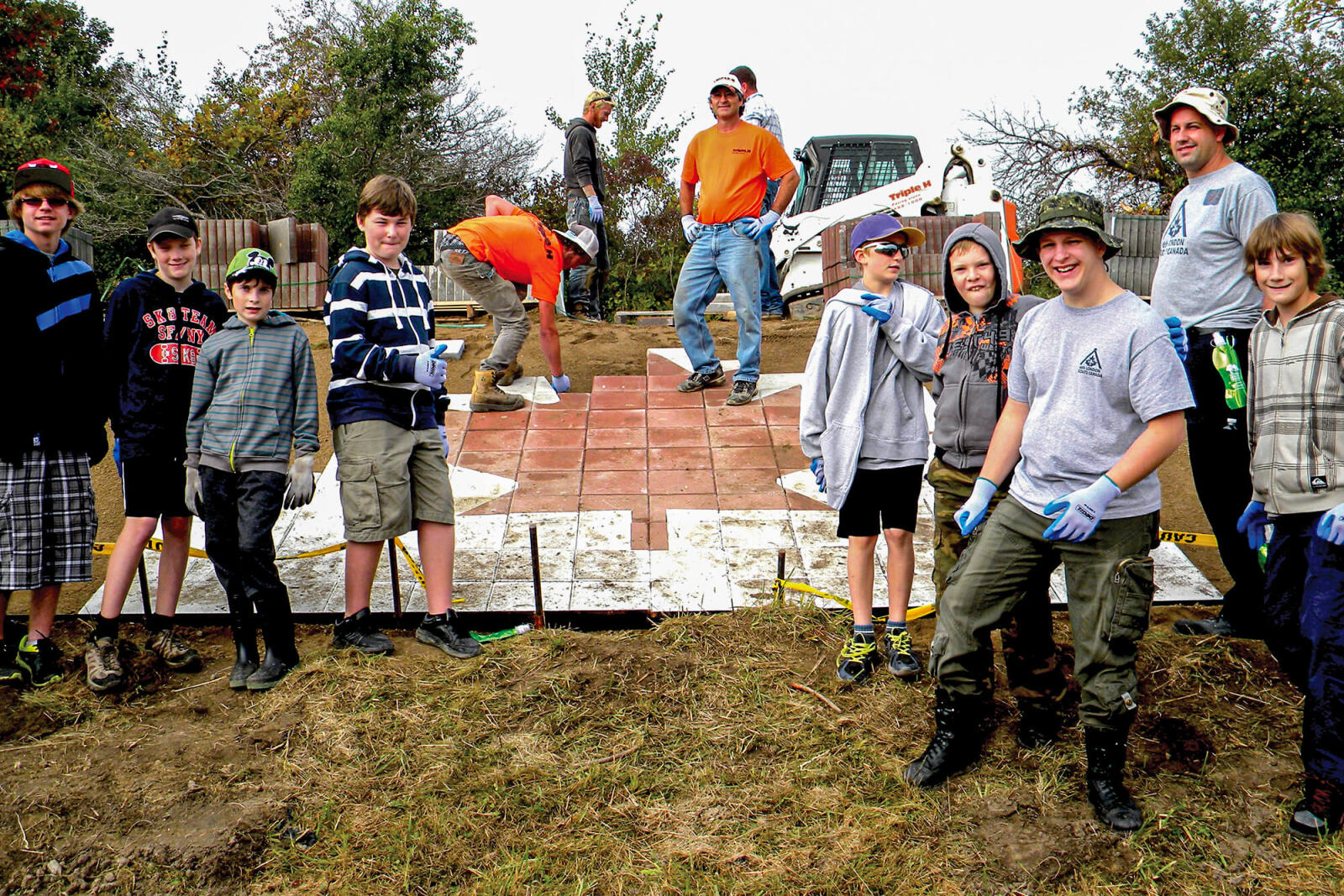 group of kids helping to build a candian flag out of pavers