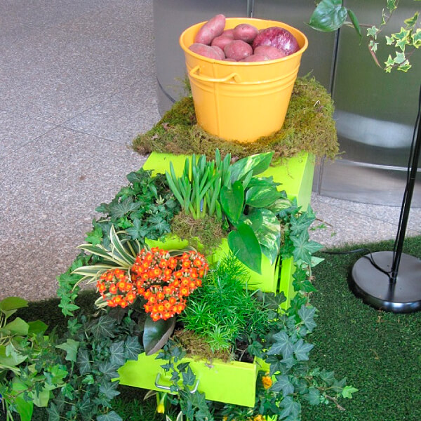tower of yellow pots with plants growing in them