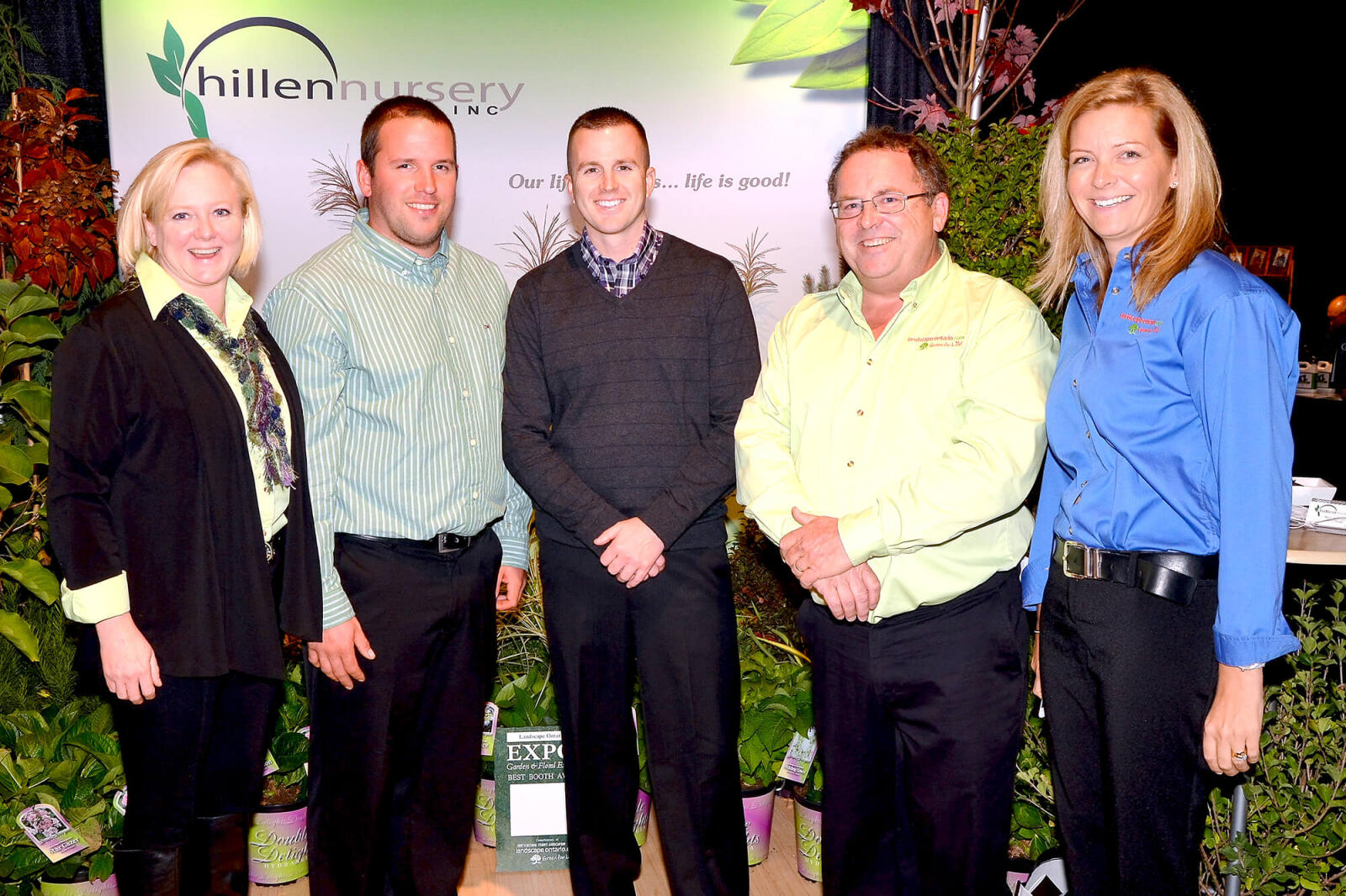 5 people standing in front of a trade show booth