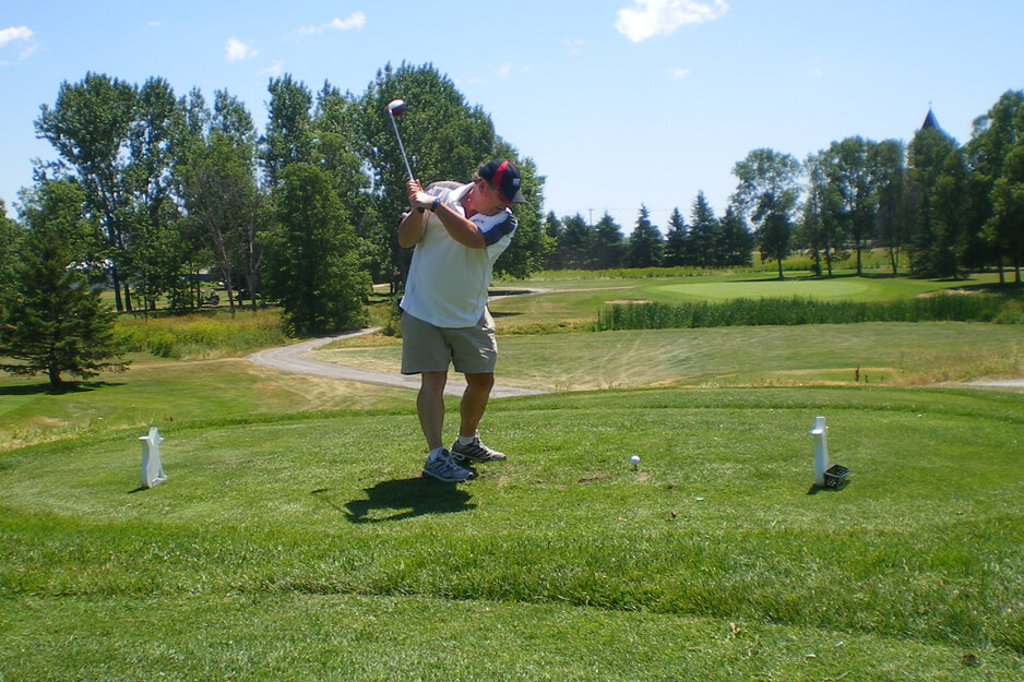 man teeing off on a golf course hole