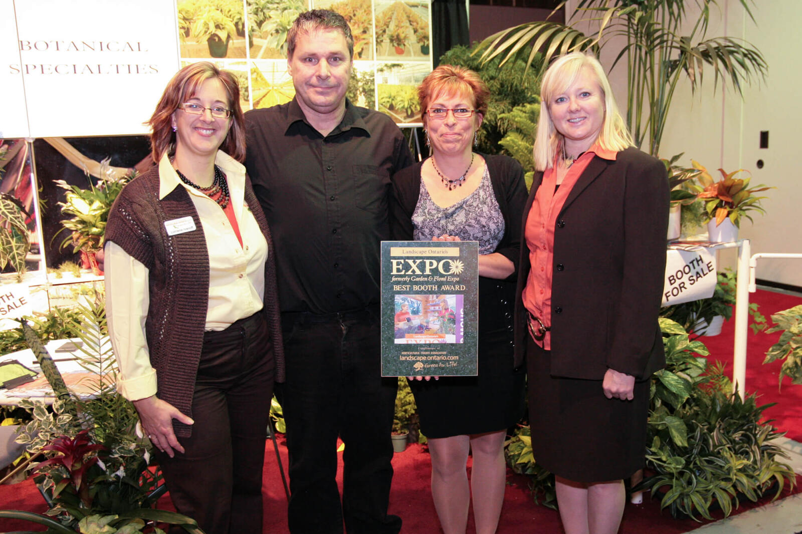 four people, one holding an award