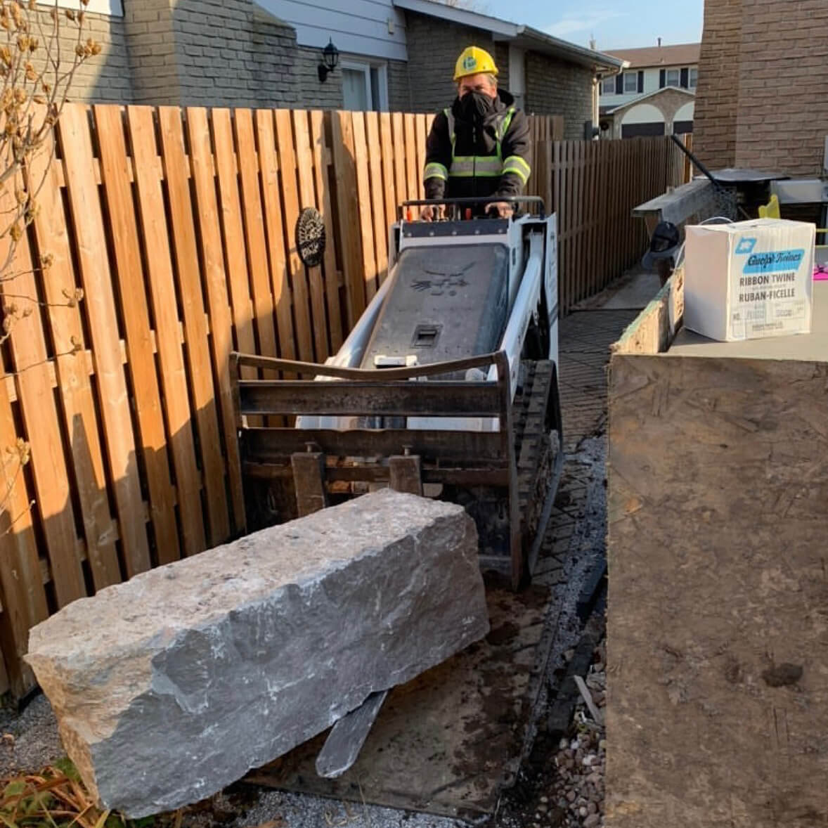 man using a machine to move a large stone