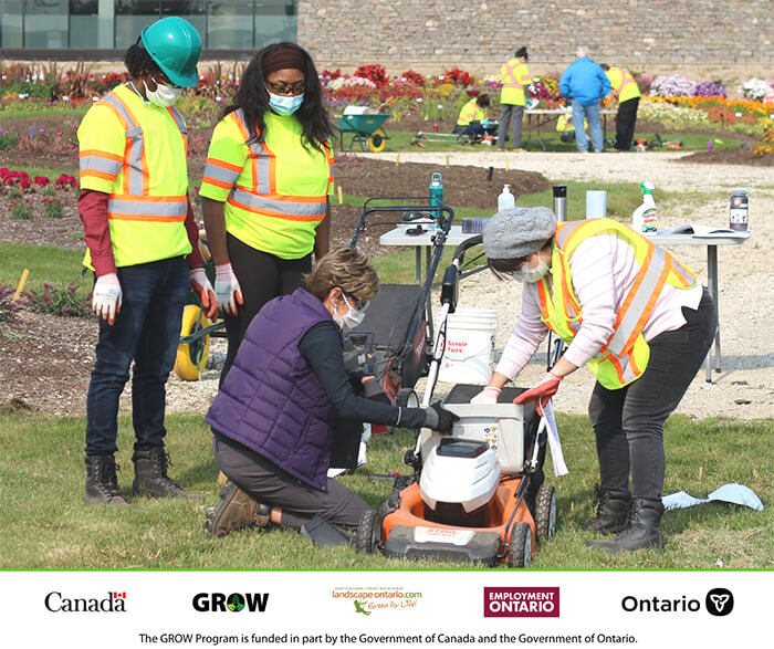 group of people looking at a lawnmower