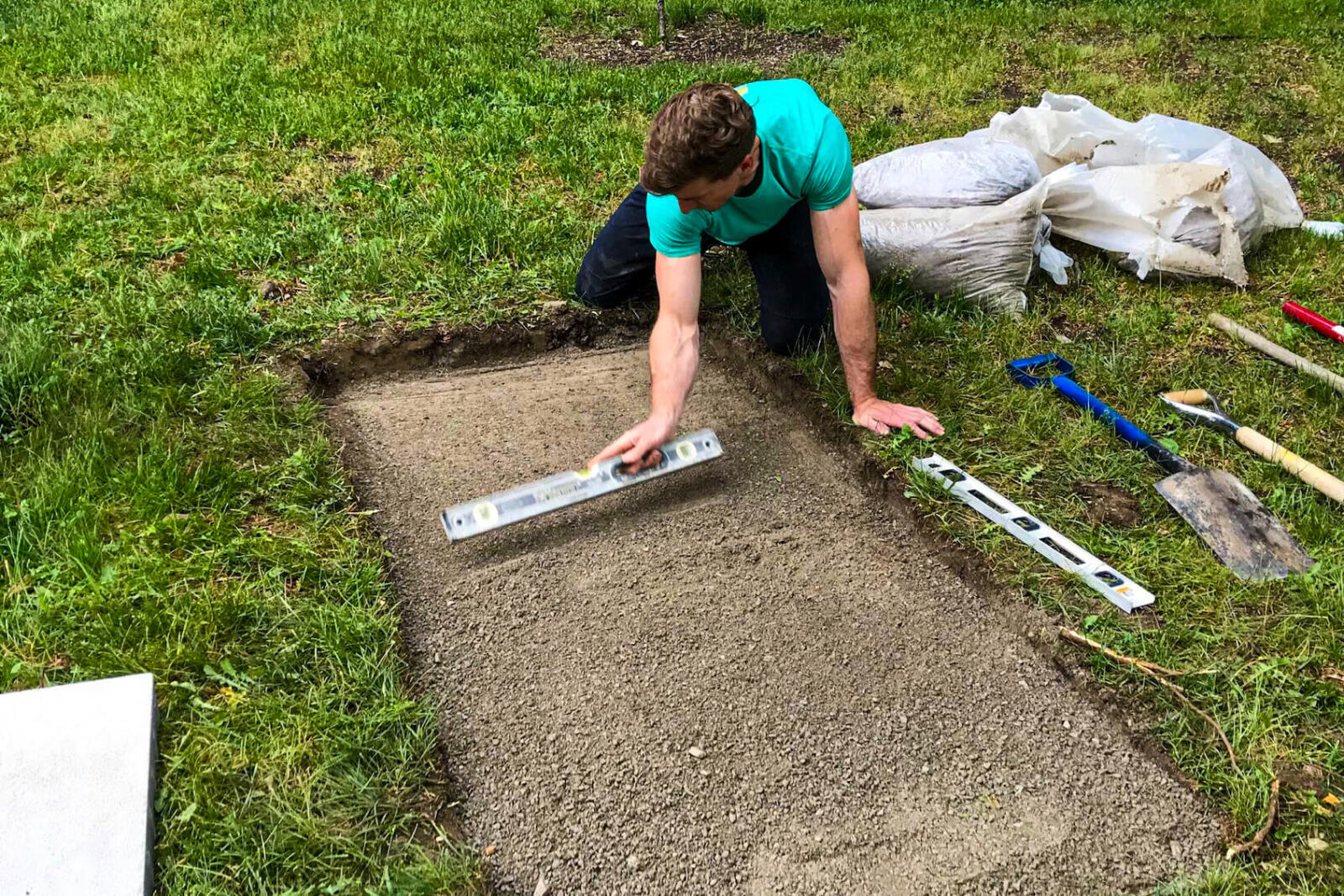 man preparing to pour a concrete slab on a lawn
