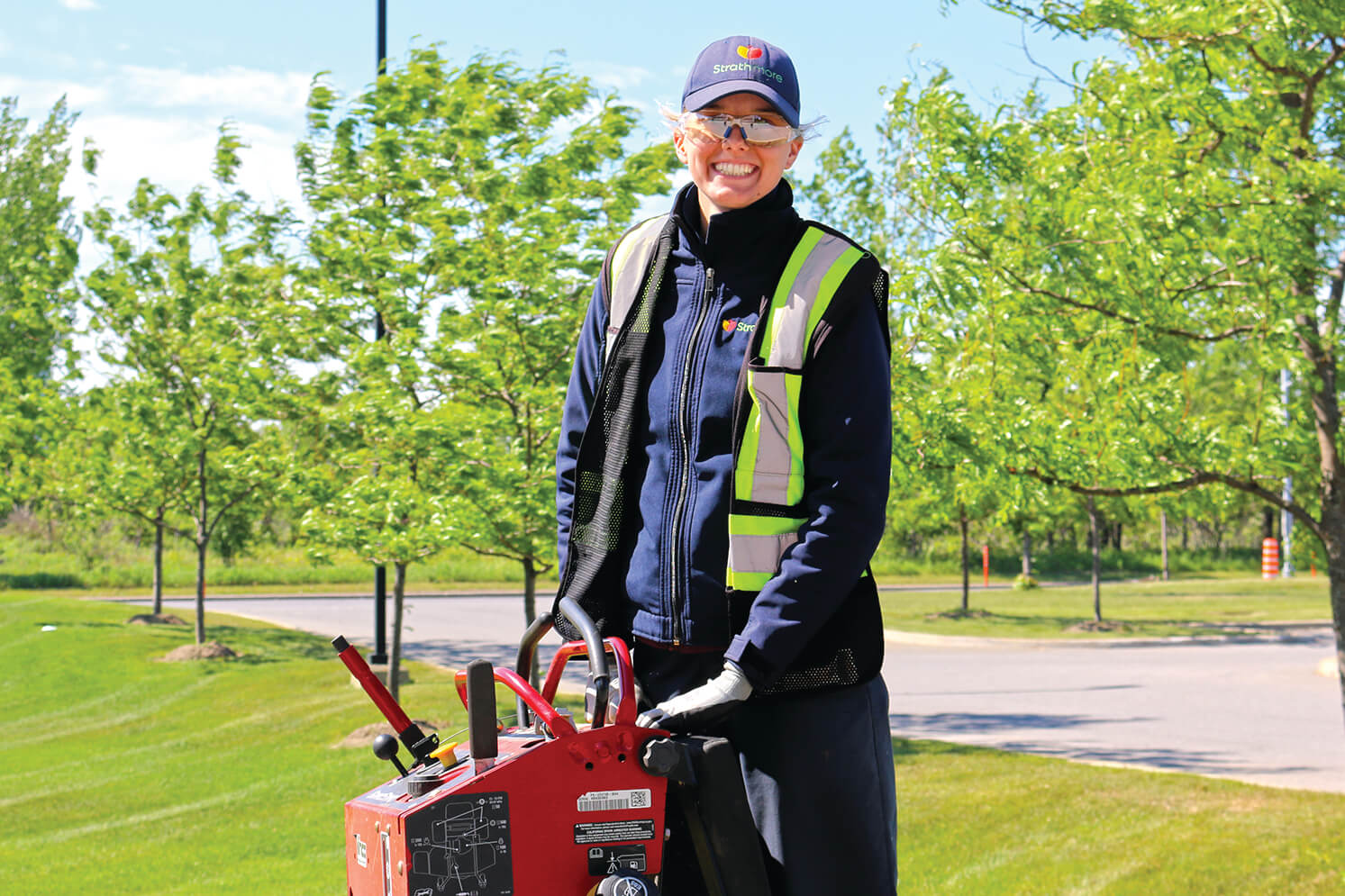 person standing on a riding lawn mower outside