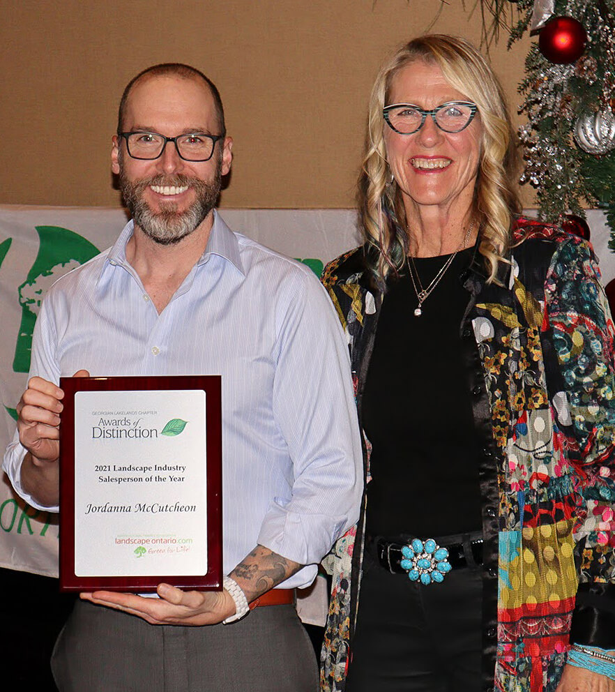 two people one holding a plaque